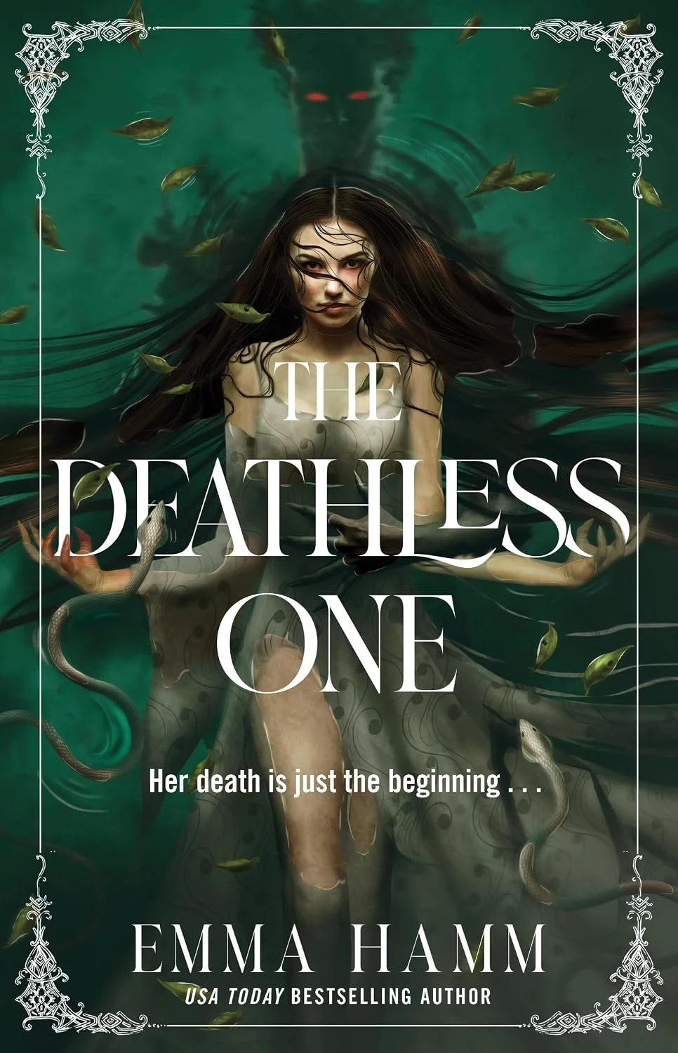 Book cover of "The Deathless One" by Emma Hamm, featuring a young woman with long dark hair and intense red eyes, partially submerged in water, with snakes intertwined around her. The tagline reads "Her death is just the beginning..."