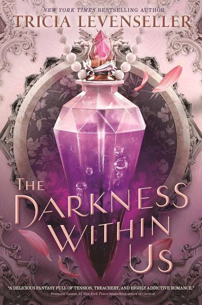 Book cover of "The Darkness Within Us" by Tricia Levenseller, featuring a pink, faceted gem with rosequartz appearance, surrounded by a pearl necklace and scattered pink flower petals. The background has ornate, gray swirling patterns.