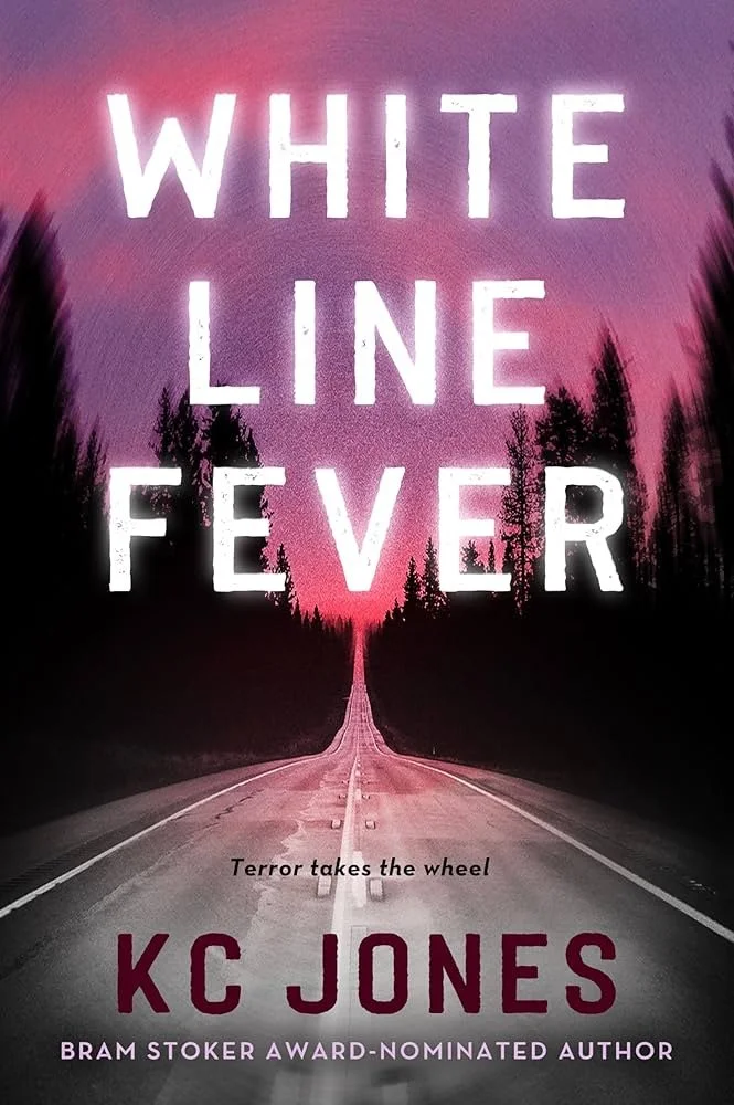 Book cover titled "White Line Fever" by KC Jones with the tagline "Terror takes the wheel." The background features a long, empty road through a forest with a pink and purple sunset or sunrise sky.