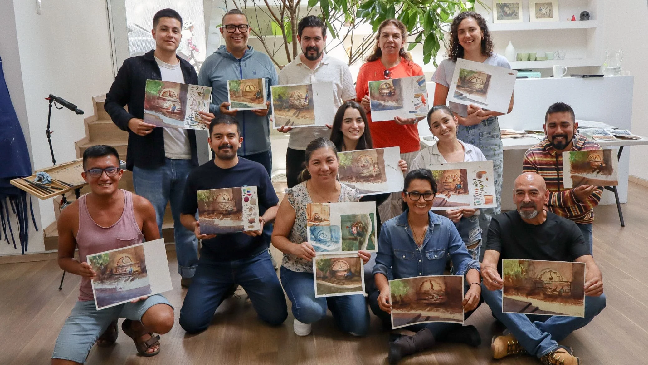 Grupo de personas en una sala de arte, sosteniendo pinturas que representan un reloj gigante en un entorno natural y escenas de interior, todos sonriendo y posando para la foto.