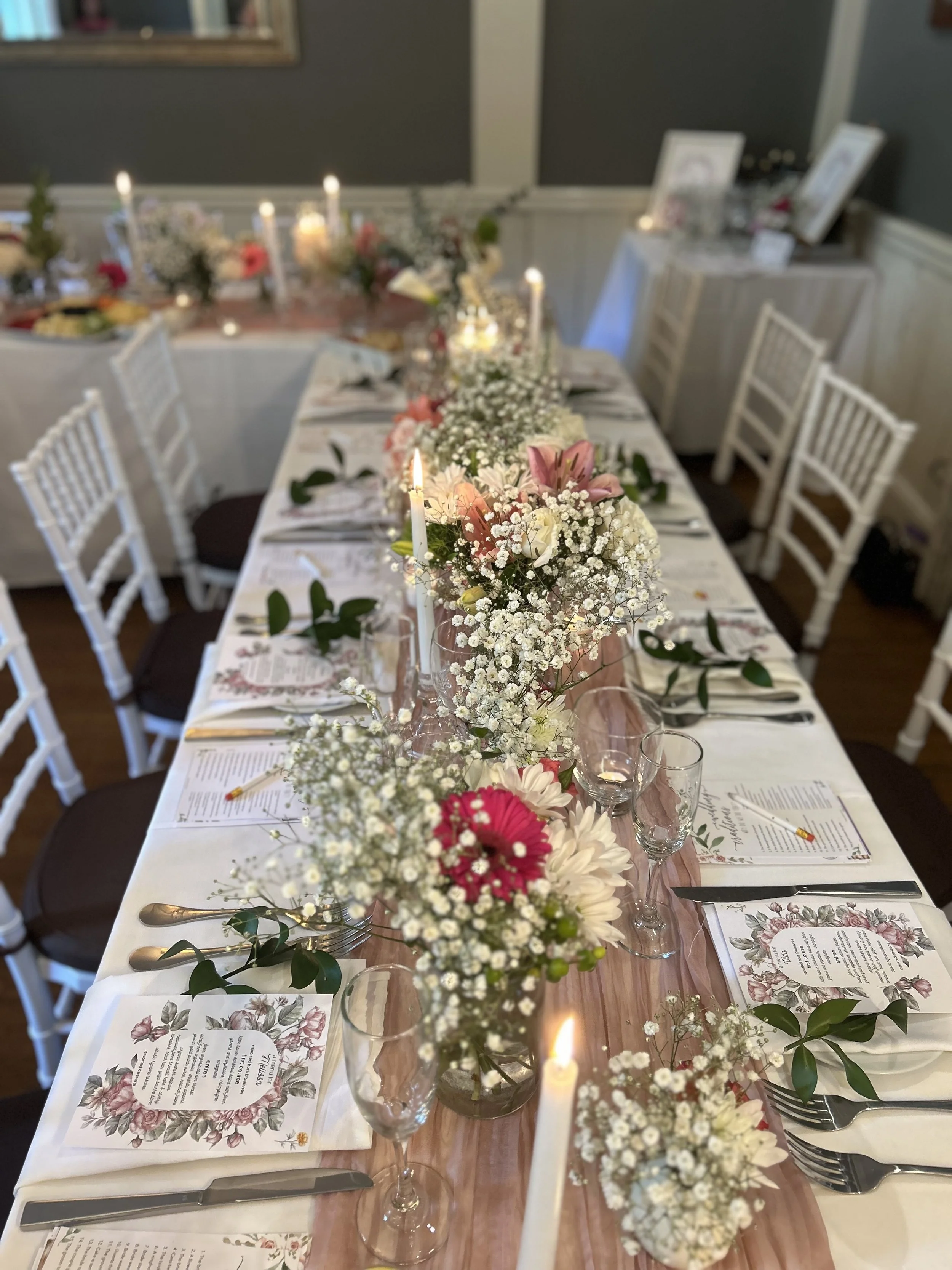 Elegant wedding reception table decorated with floral arrangements, candles, and printed menus, set for a formal dinner. Wedding & Event Planner Hudson Valley, NYC, New York, Bergen County, New Jersey