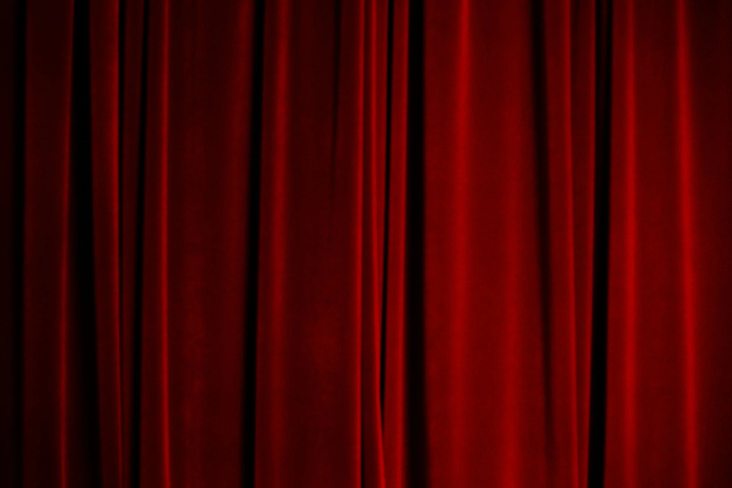 Rich red fabric draping with deep folds, demonstrating how bold color and texture can create drama and emotional impact within a space