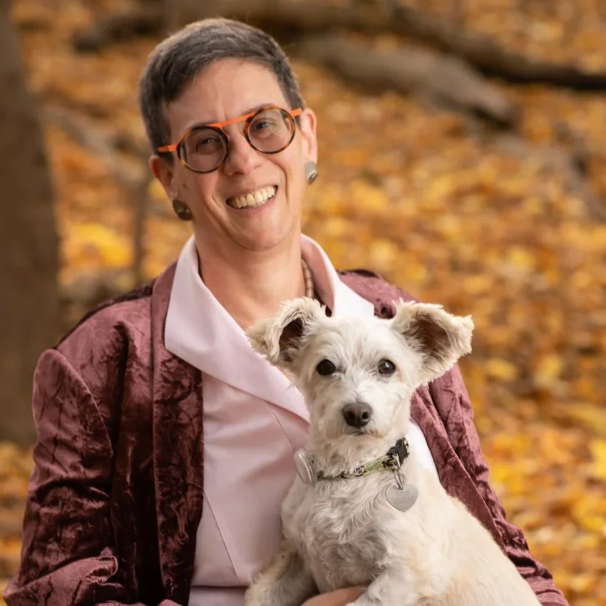 Civil rights and employment attorney Robin, smiling outdoors while holding a small dog.