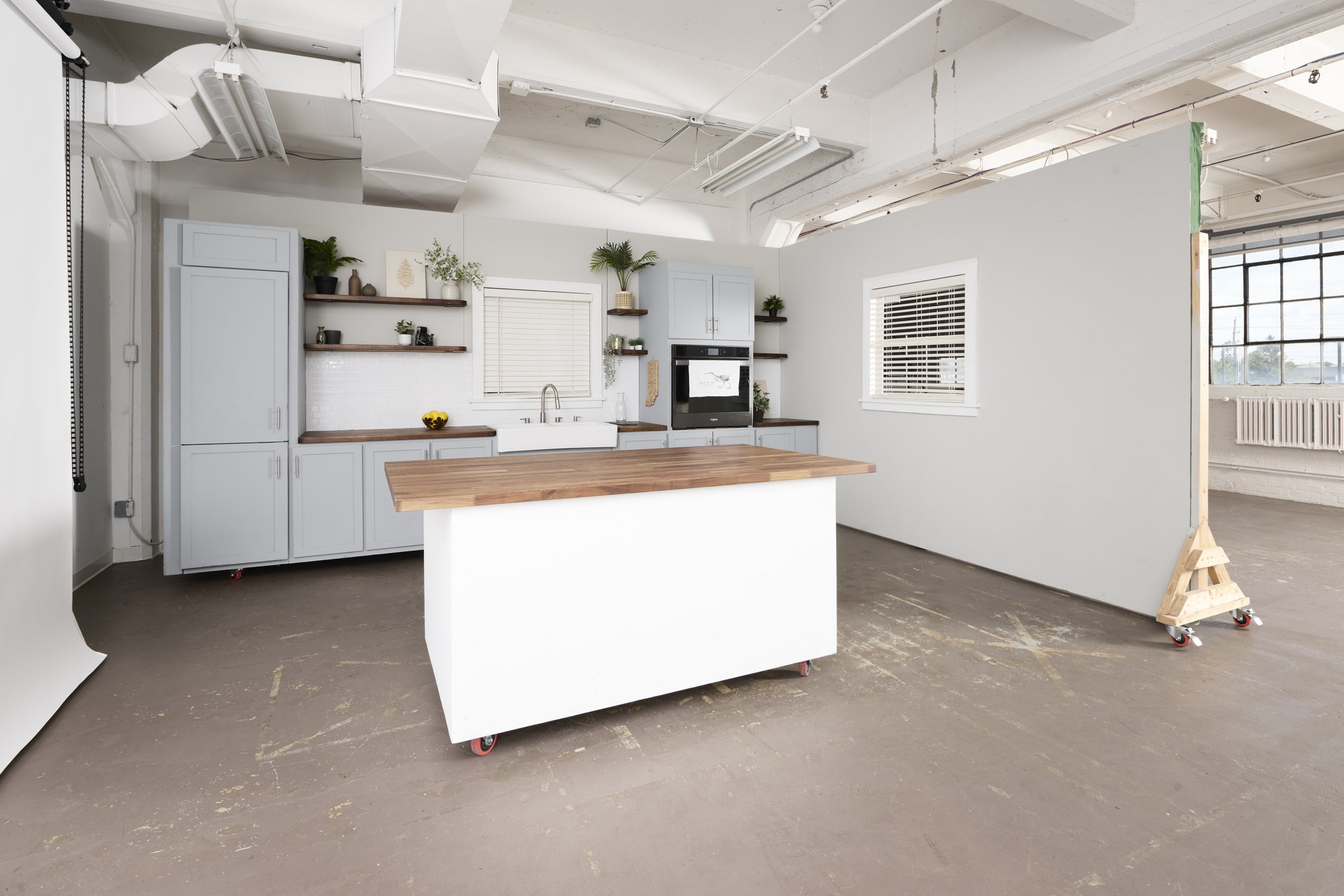 Kitchen set with island, and mobile wall with East window wall behind