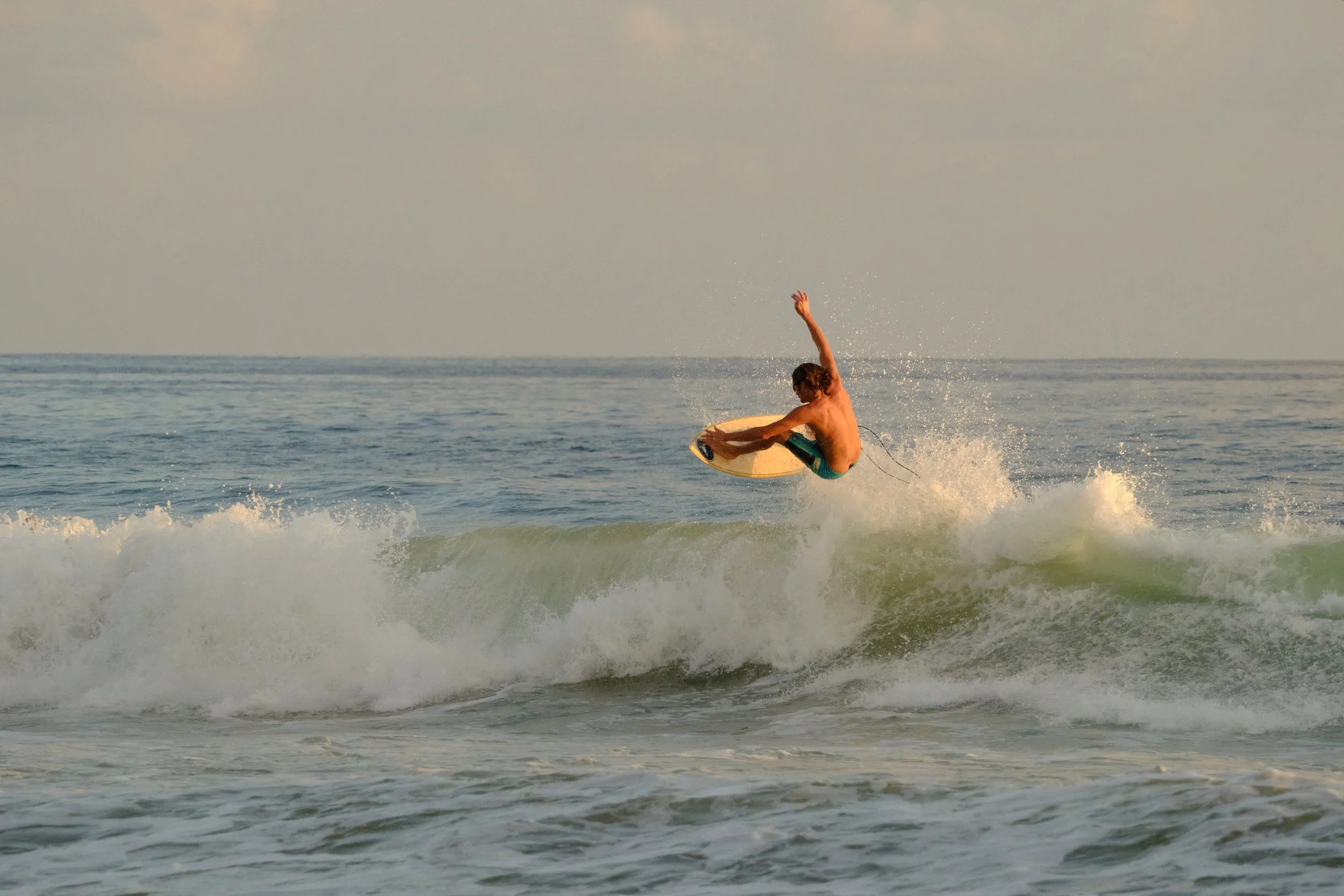 A person surfing on a wave in the ocean during daytime.