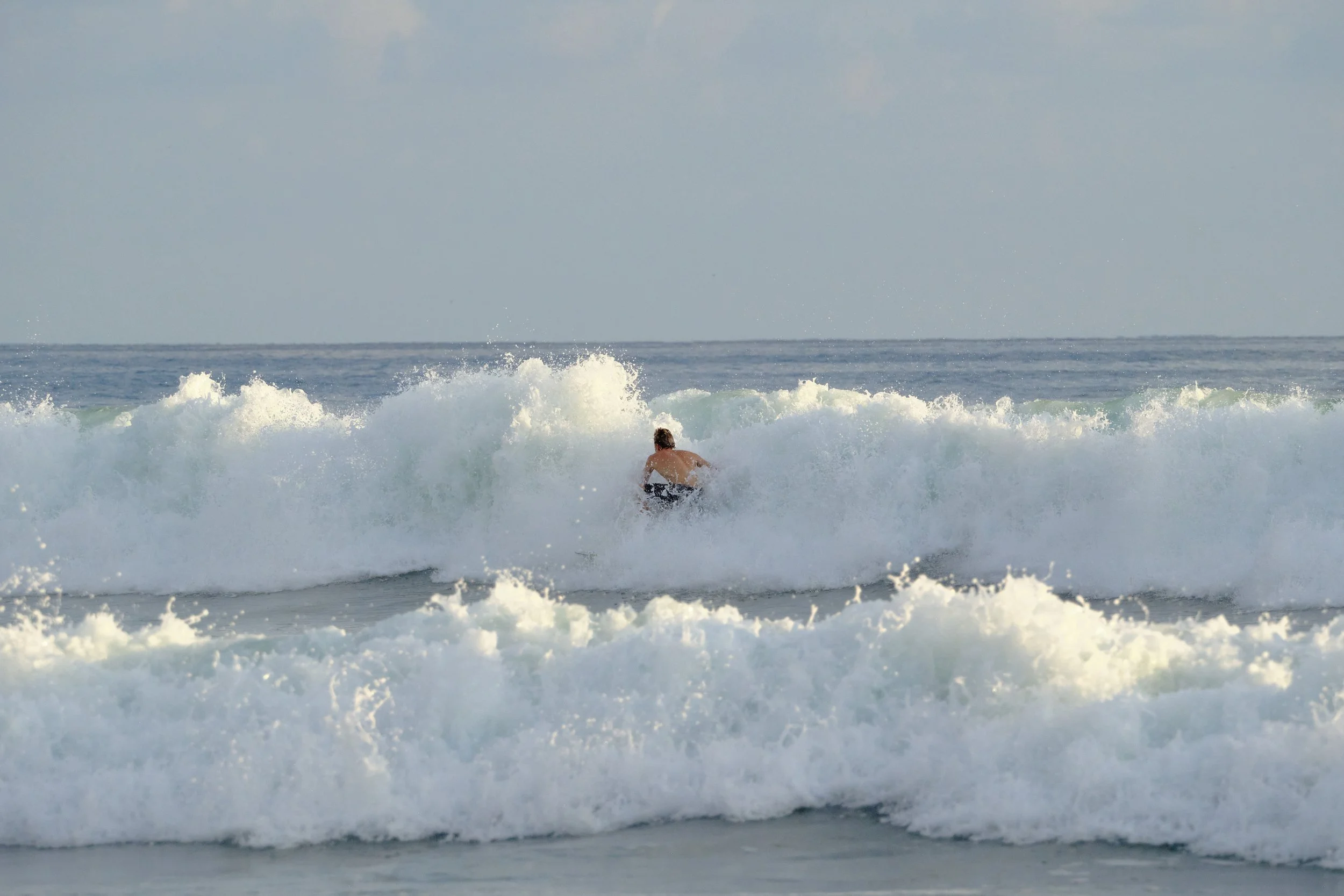 A person surfing on a wave in the ocean.