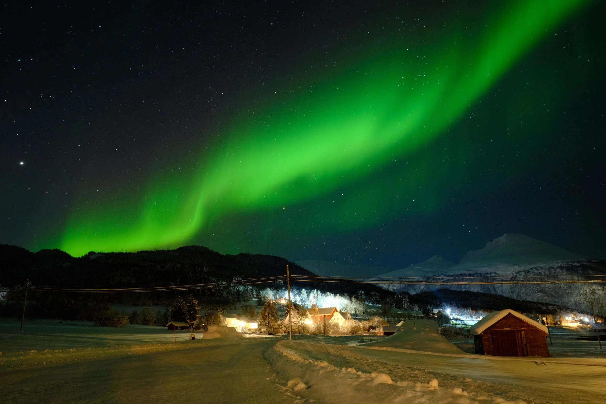 As the last traces of twilight disappeared, I drove beyond Tromsø into the silent Arctic countryside, where darkness slowly revealed the night sky. The cold was relentless, forcing me back into the warmth of the car every few minutes as my fingers fr