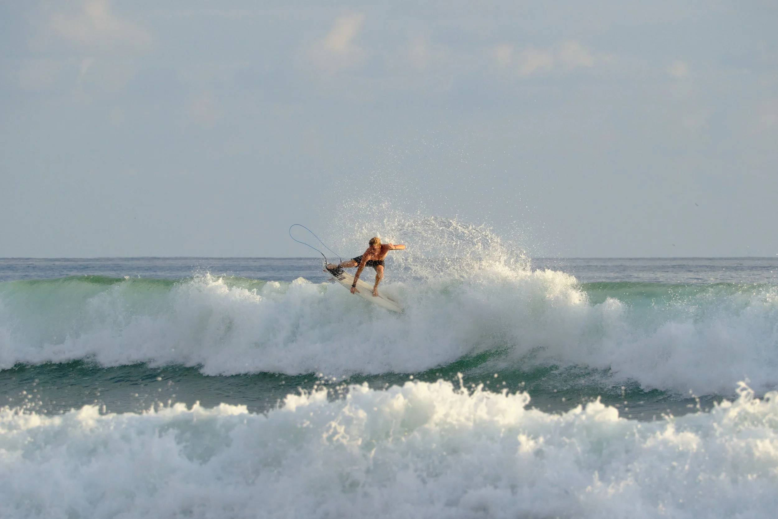 A person surfing on a wave in the ocean during daytime.