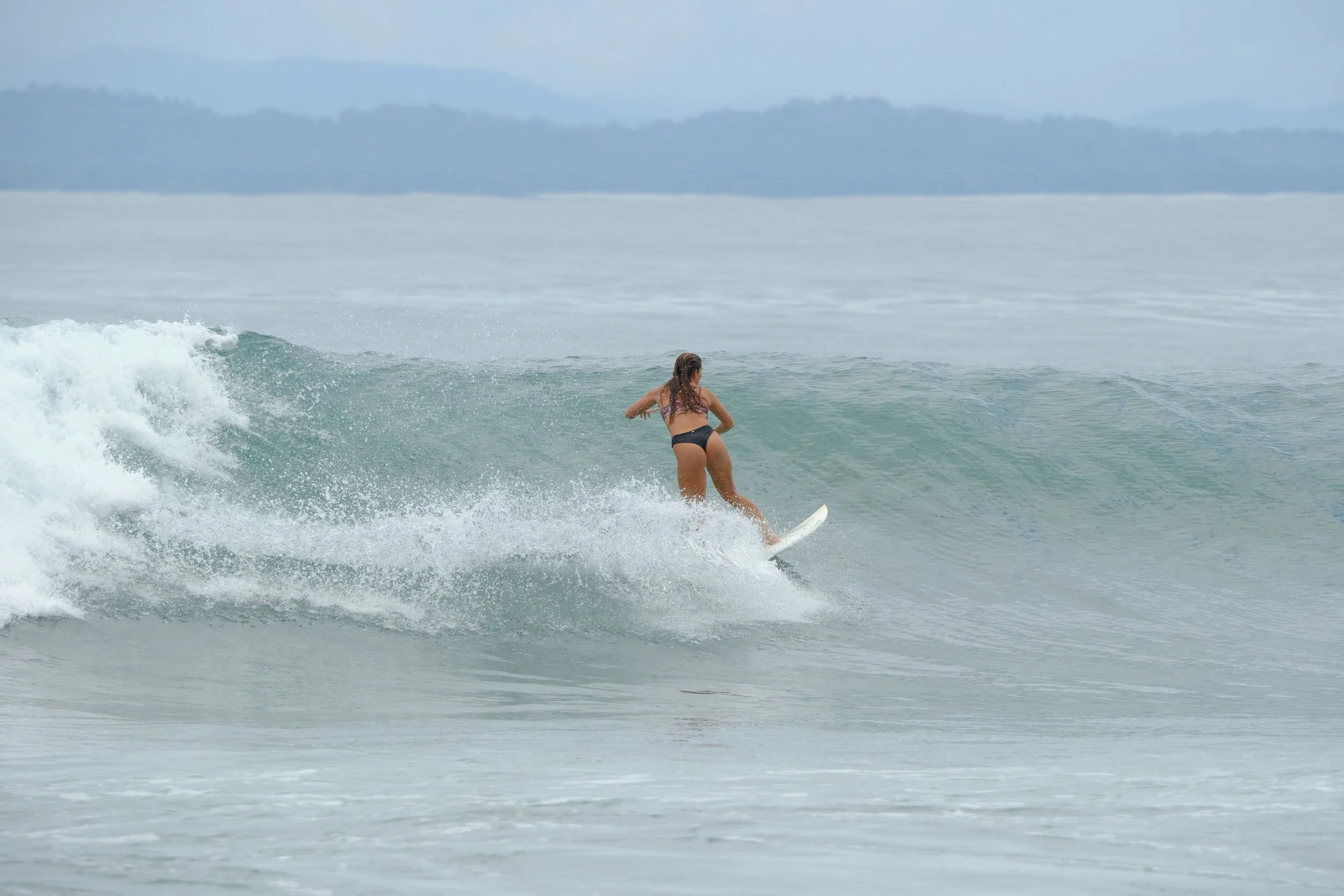Woman surfing on a wave in the ocean during daytime