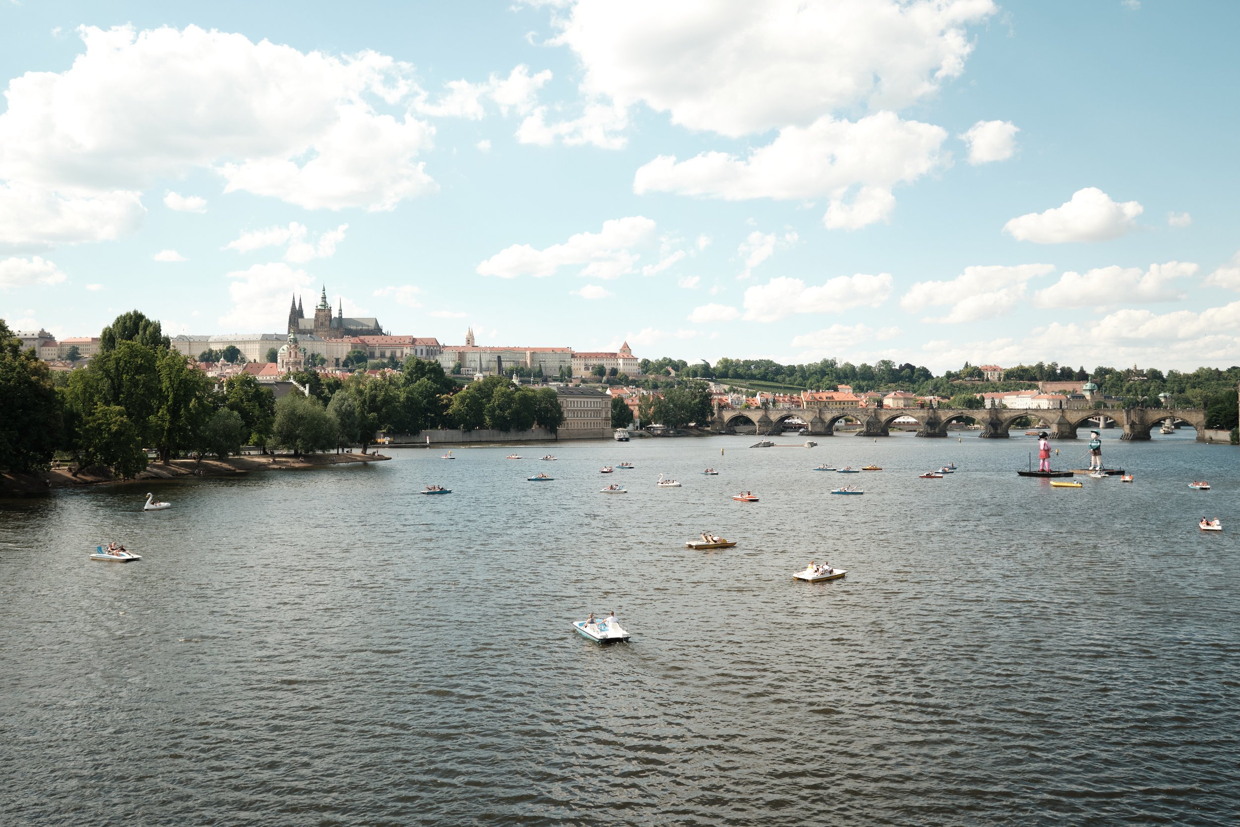 My first afternoon in Prague happened to be a sunny Sunday, and the city couldn’t have offered a warmer welcome. Couples drifted along the Vltava River, people gathered beneath the summer sky, and the skyline of Prague Castle and Charles Bridge rose 