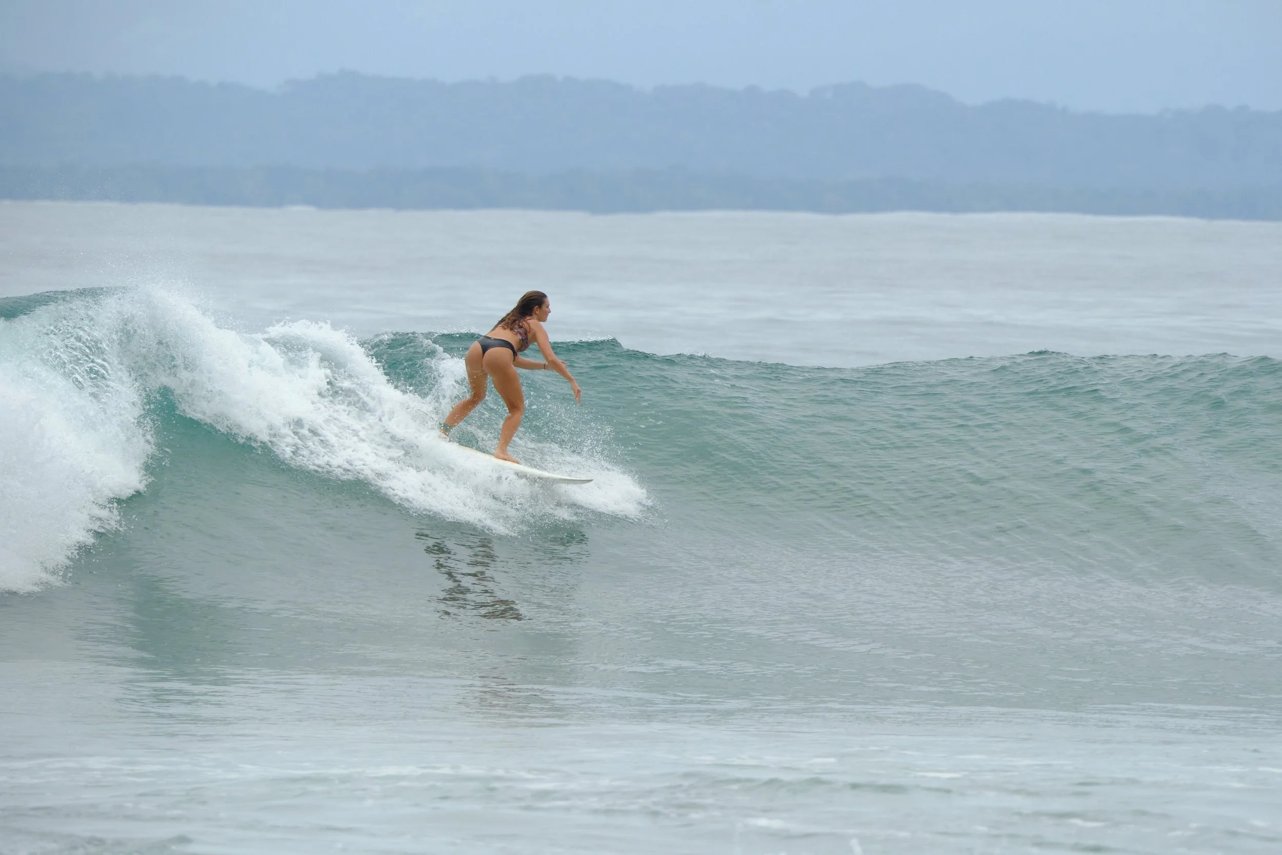 A woman surfing on a wave in the ocean.
