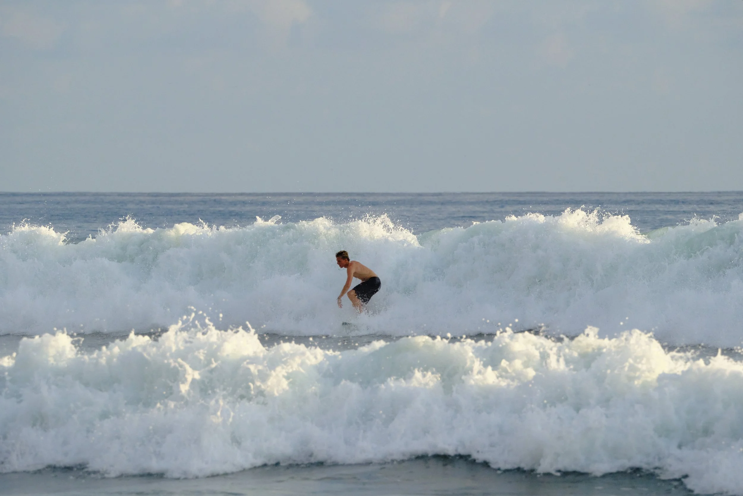 A person surfing on a wave in the ocean