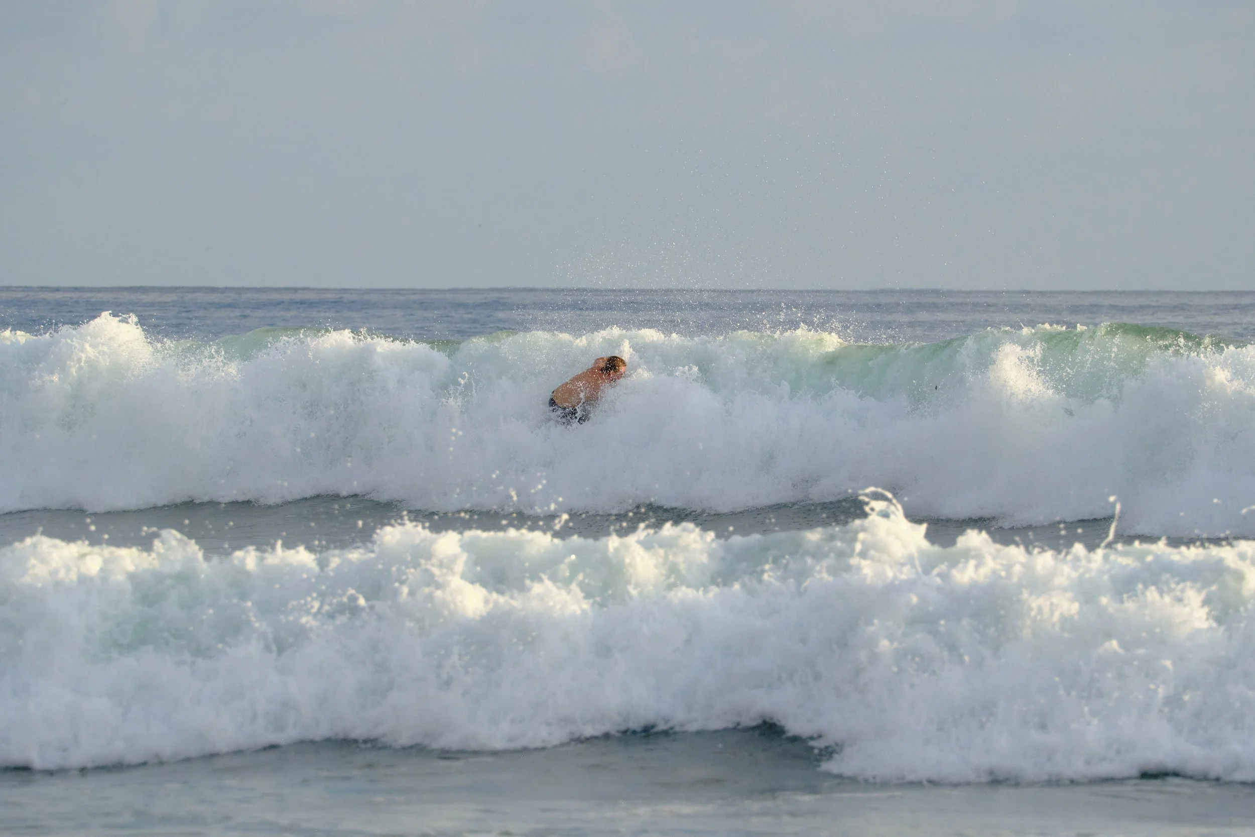A person surfing on a wave in the ocean.