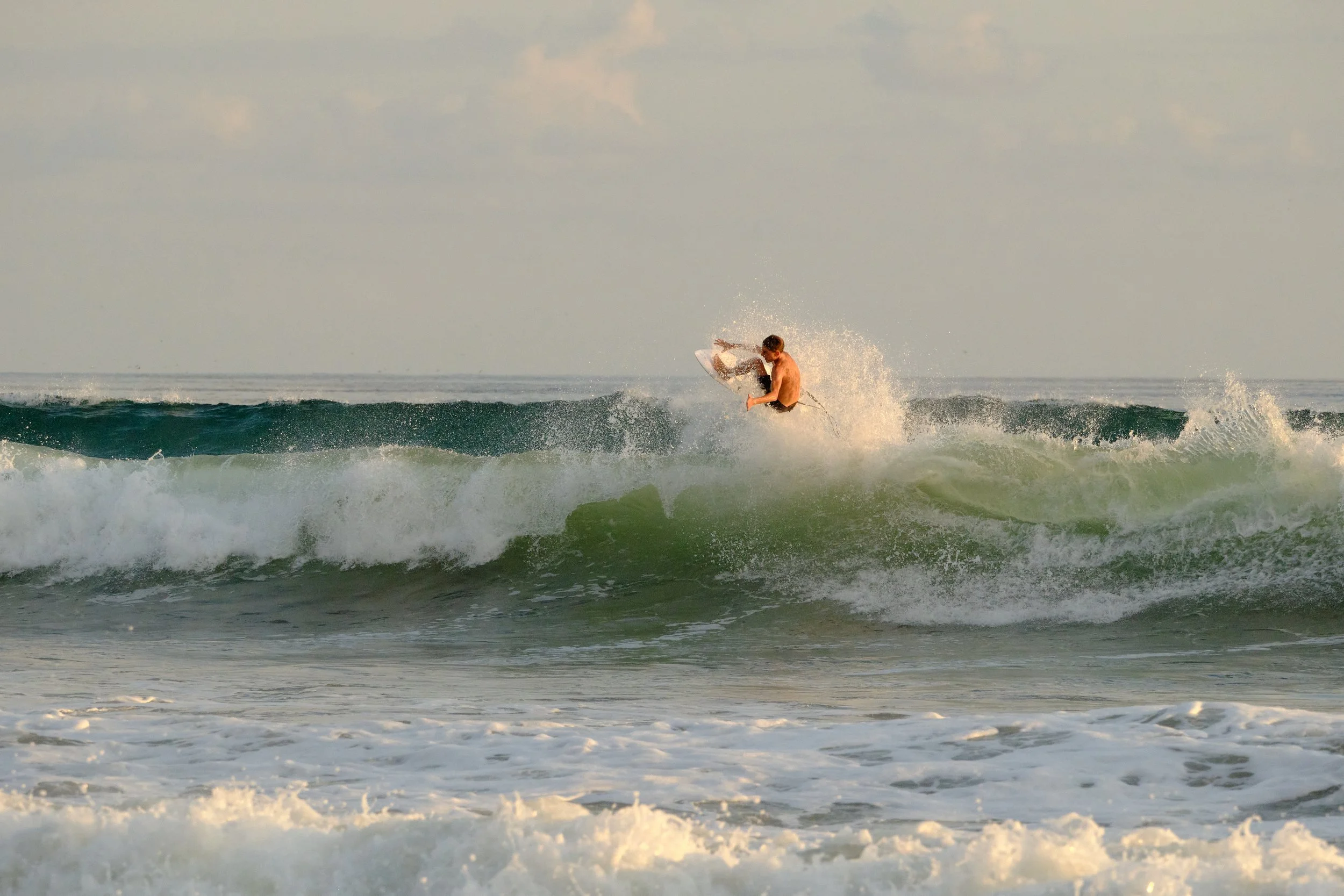 A person surfing on a wave in the ocean during daytime.