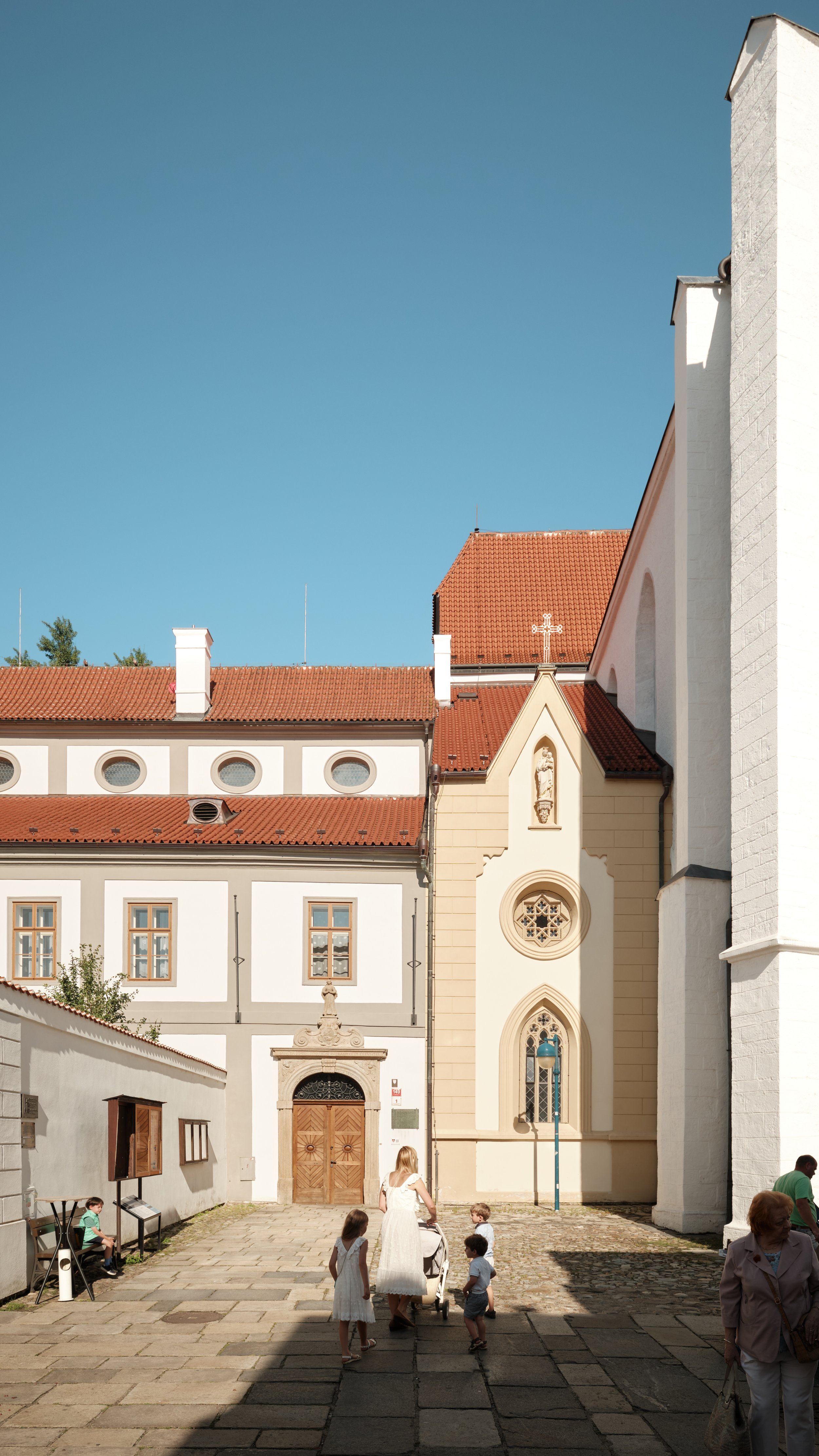 On a quiet Sunday morning, the Cathedral of St. Nicholas stood above a peaceful courtyard where families, warm light, and centuries-old architecture came together in a scene that felt both timeless and alive.