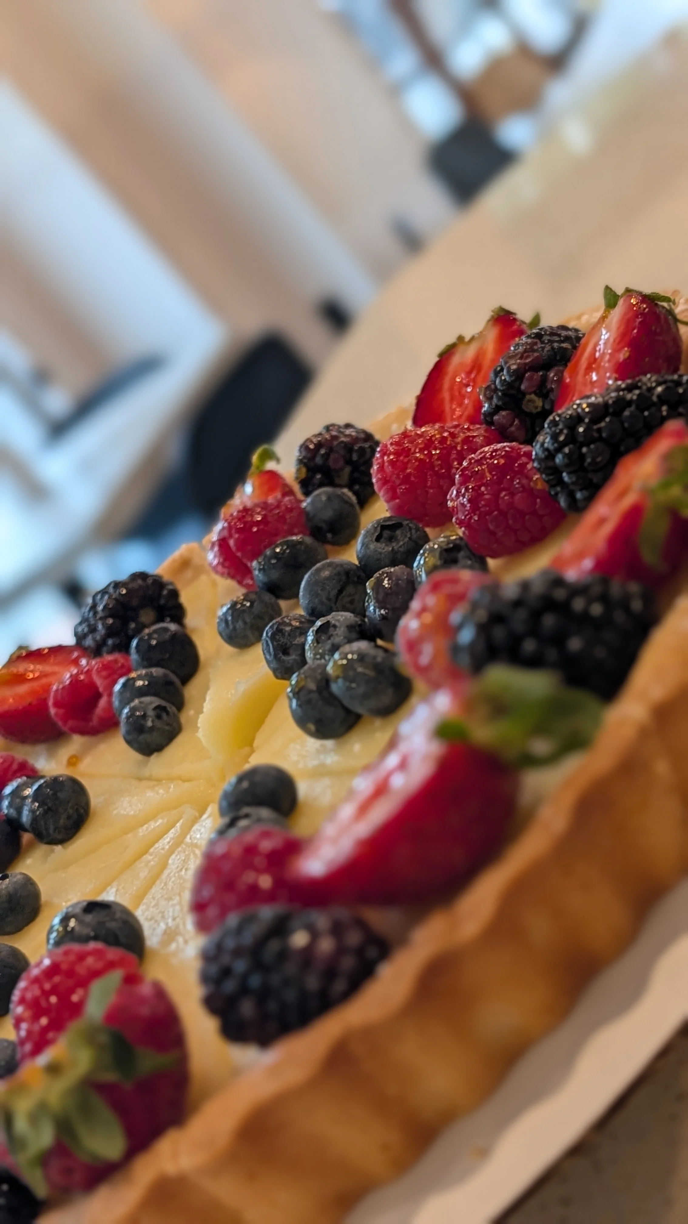 Close-up of a fruit tart topped with strawberries, blueberries, blackberries, and raspberries.