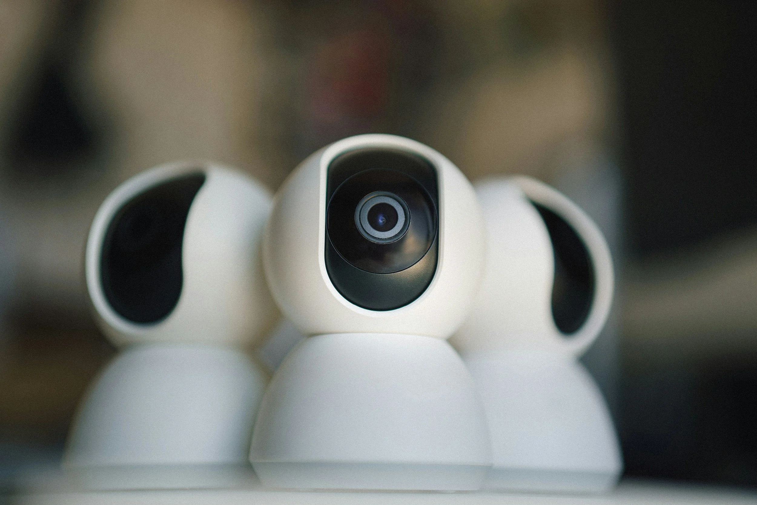 Three white dome security cameras with lenses in view.