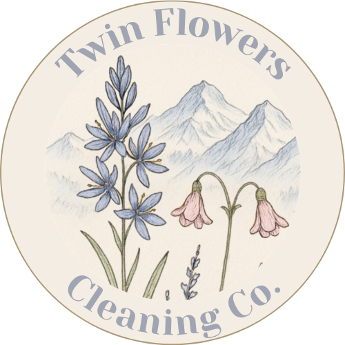 Logo for Twin Flowers Cleaning Co. featuring illustrations of purple flowers and pink bell-shaped flowers with mountain in the background.