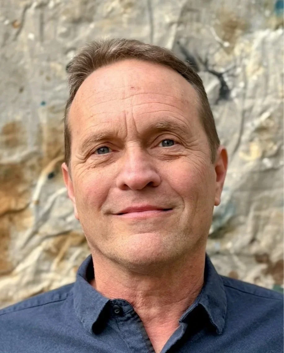 Fritz Kling smiles outside with a dark blue collared shirt