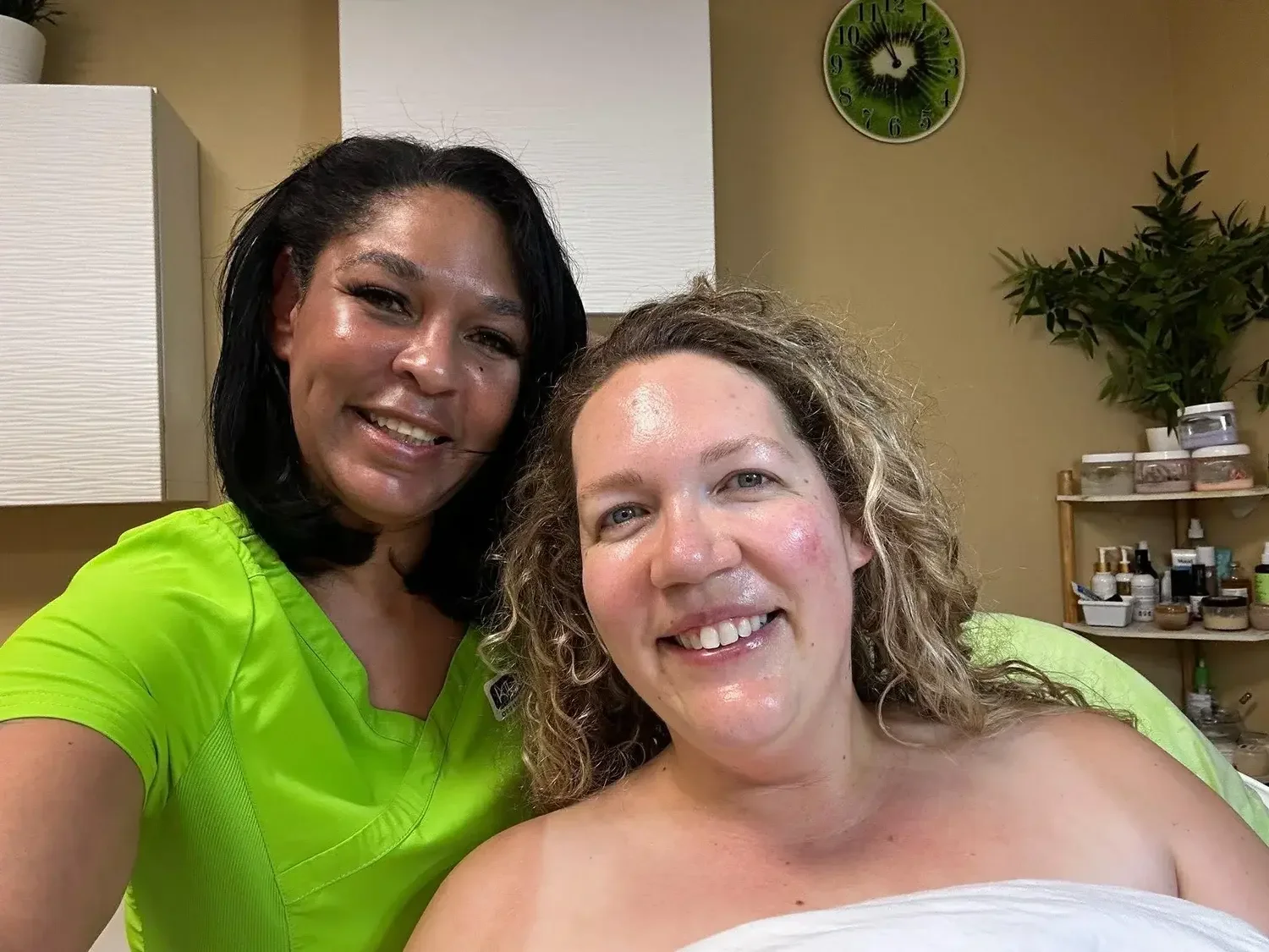 A woman with glowing skin smiling with her esthetician from her JetPeel facial at Kiwi Spa San Diego