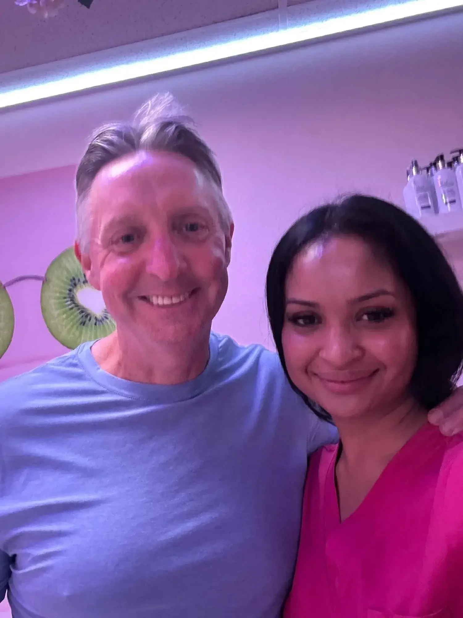 A man smiling with his esthetician after a couple's facial