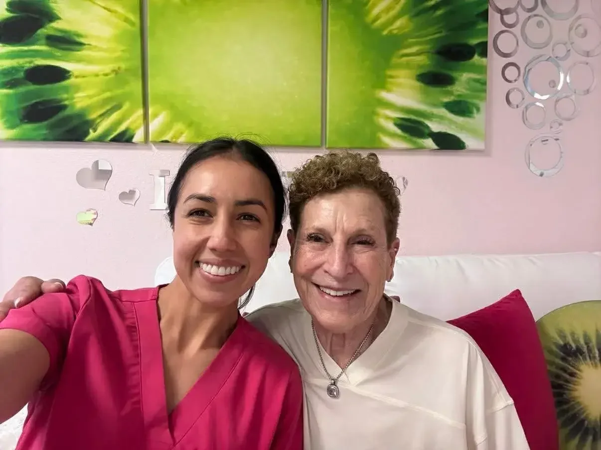A returning client at Kiwi Spa smiling with her esthetician