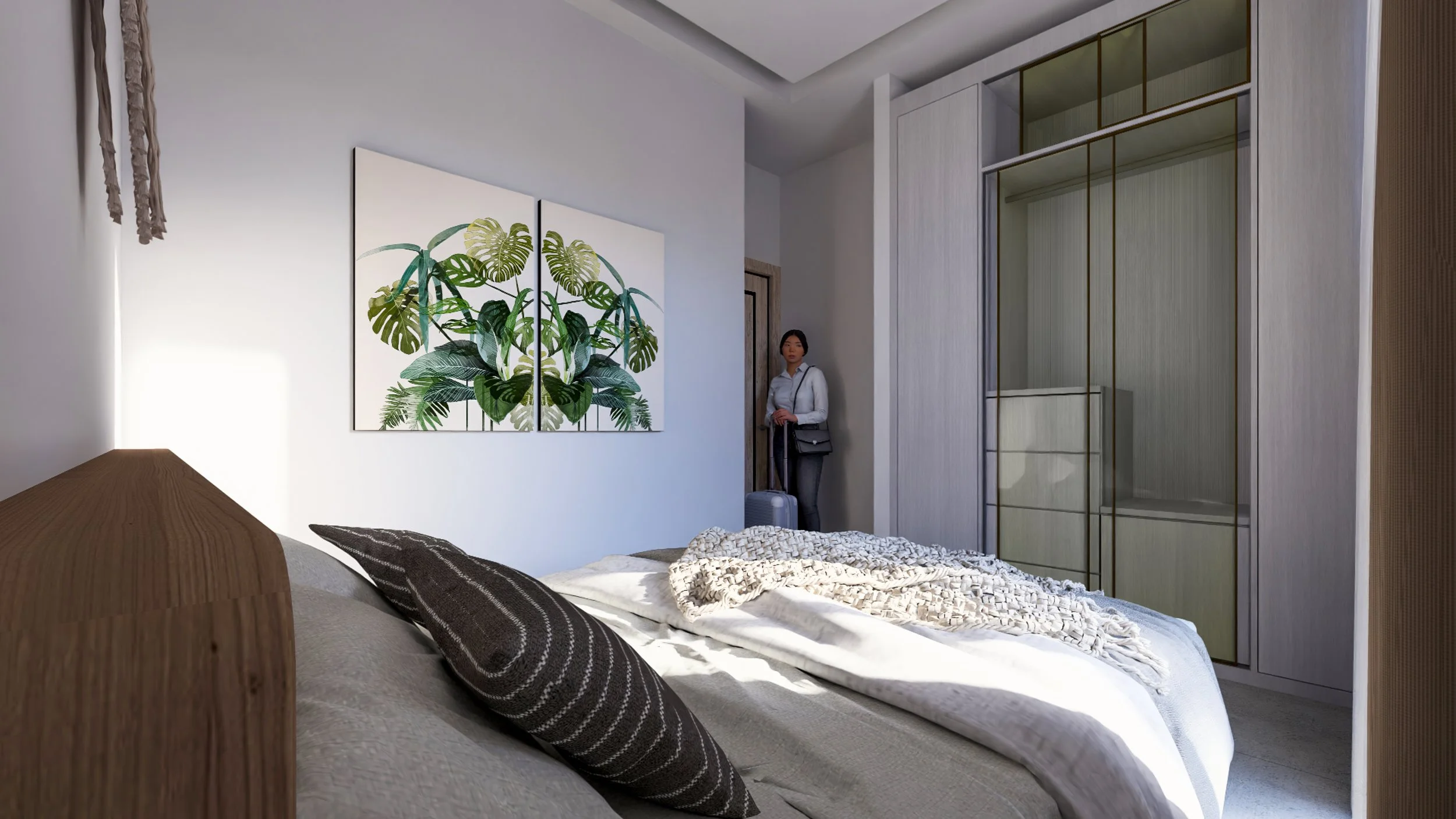 Modern bedroom with a bed featuring beige bedding, black and brown striped pillows, a foldable blanket, white walls, a wardrobe with glass doors, artwork of green tropical leaves, and a woman with briefcase standing near the door.