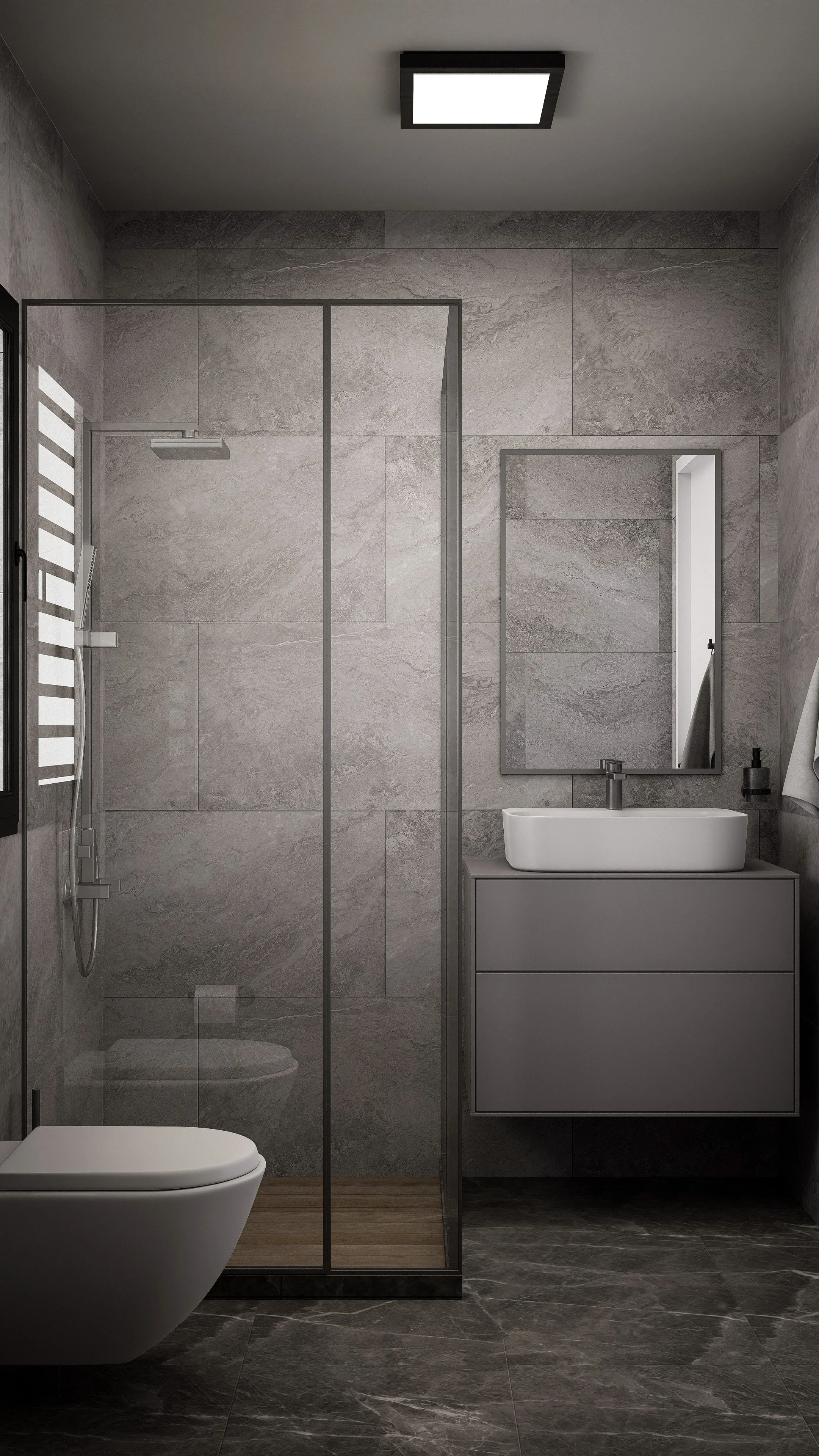 Modern bathroom with gray marble tiles, a walk-in glass shower, a wall-mounted toilet, a gray vanity with a white rectangular sink, a mirror, and minimal accessories.