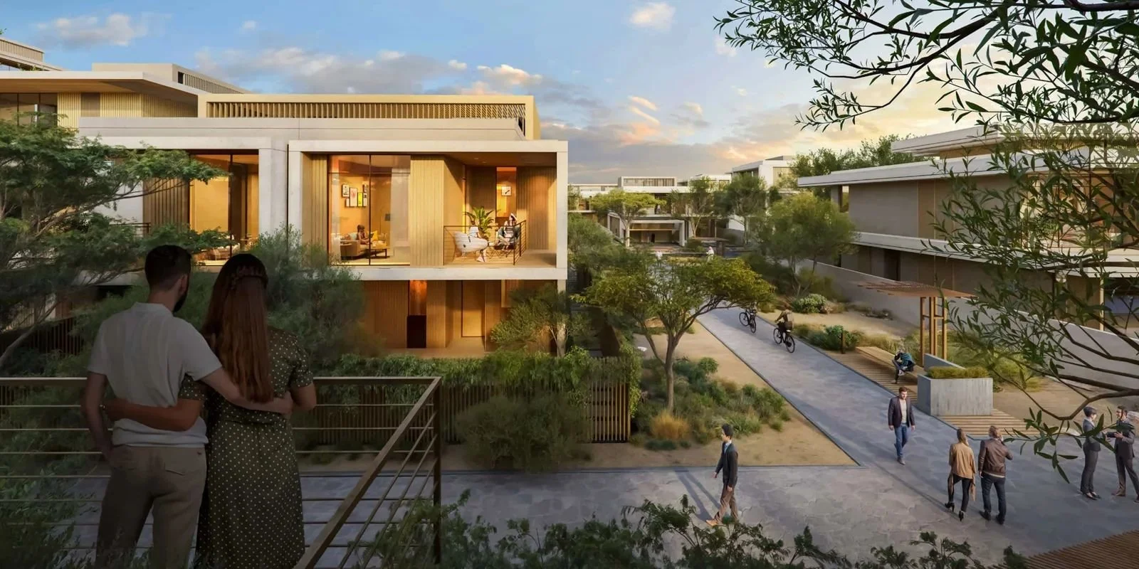 Modern residential complex with landscaped courtyard, walking paths, and residents socializing outdoors at sunset.