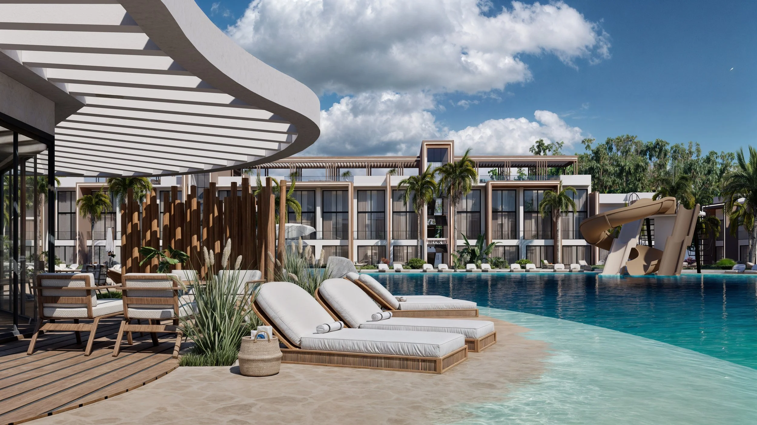 Luxury hotel pool area with lounge chairs, water slide, palm trees, and modern building interior visible through glass walls, under a partly cloudy sky.