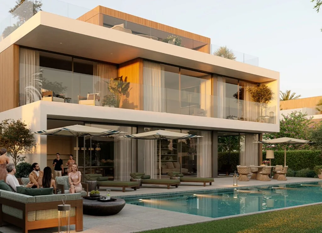 Modern multi-story house with large glass windows, outdoor pool area, and patio seating with umbrellas and lounge chairs, during sunset.