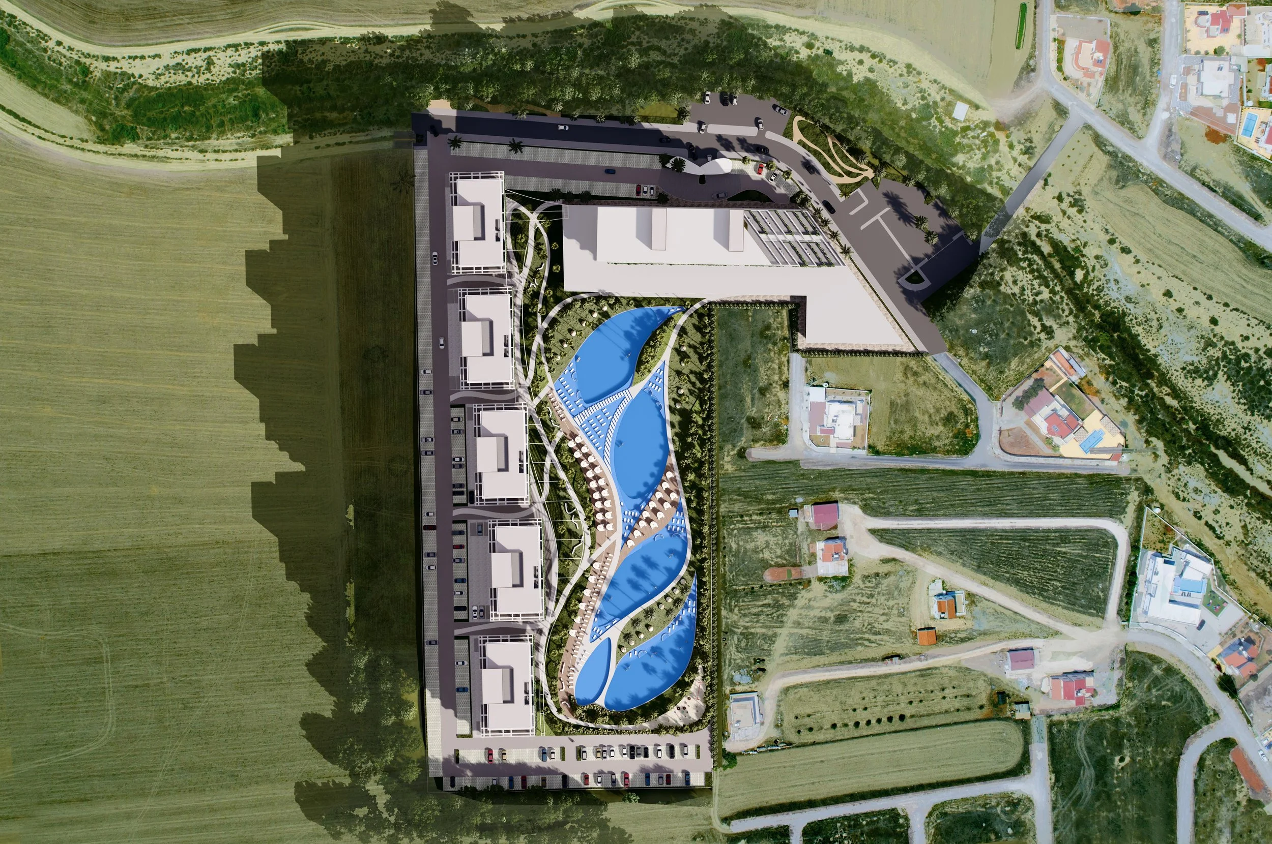 Aerial view of a large development with swimming pools, landscaped areas, and surrounding roads and fields.
