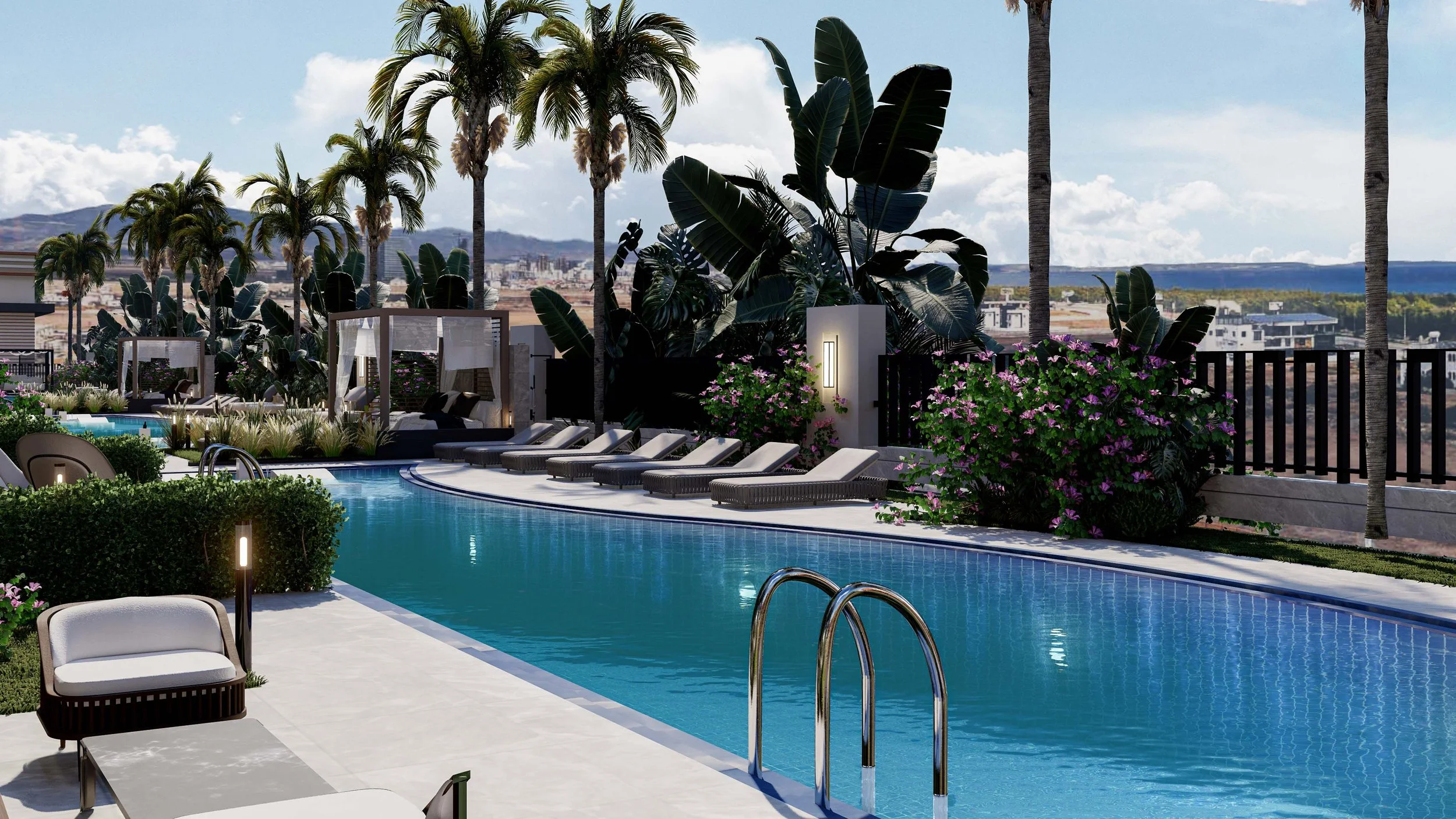 Luxury swimming pool area with lounge chairs, greenery, palm trees, and a city view in the background on a sunny day.