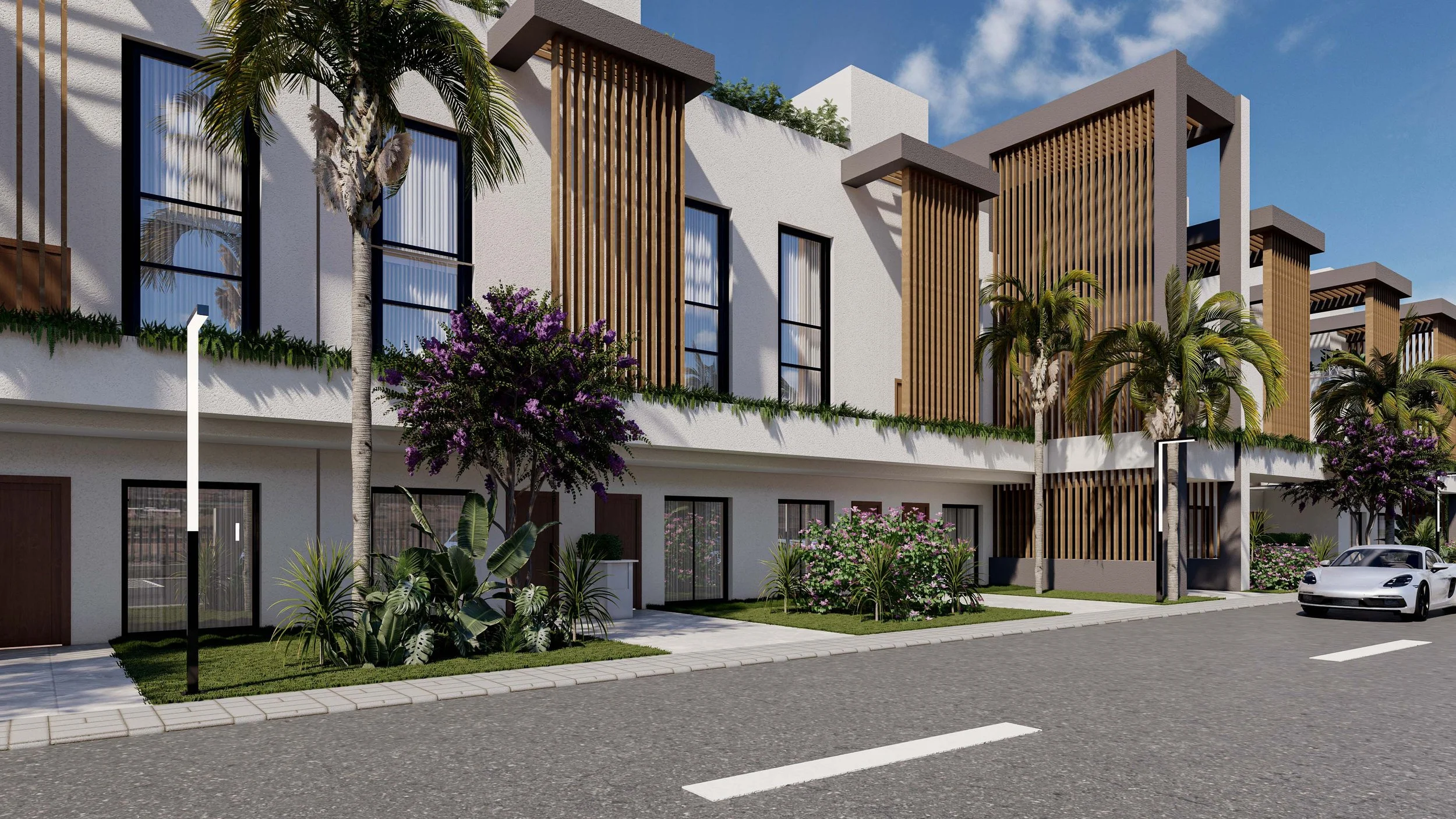 Modern residential apartment building with white exterior, large windows, and wooden architectural accents, surrounded by landscaped greenery and palm trees, with a white sports car parked on the street.