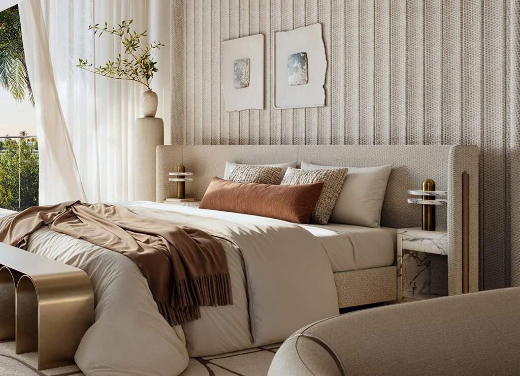 A modern bedroom with a beige upholstered bed, decorative pillows, a brown blanket, and contemporary bedside tables with marble accents. There are two abstract artworks above the bed, and a large window with sheer curtains and a view of trees outside.