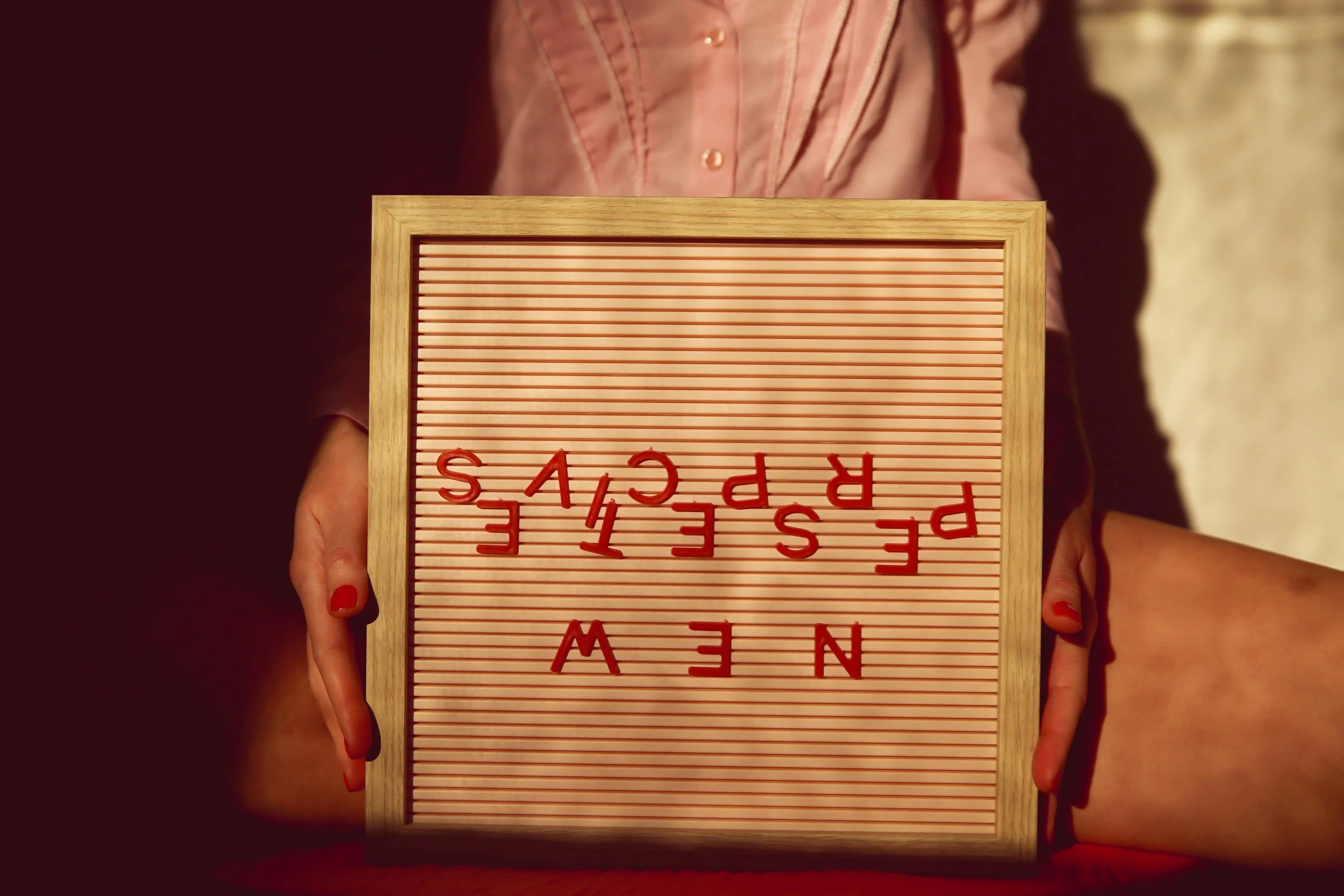 Person holding a small letter board with red letters spelling 'PEACE' and 'SPEECH' turned upside down.
