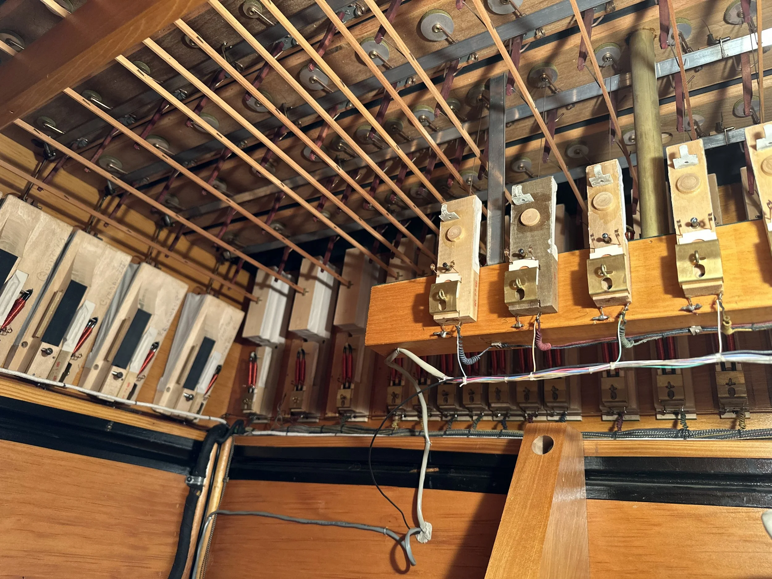 The view of the Choir stop and key actions, and the Pedal's 4' Krummhorn "internal borrow" actions hanging from the ceiling.  The 4' Krummhorn wiring was borrowed in the early 2000's to install an electronic 32' Contra Bourdon voice; this wiring was 