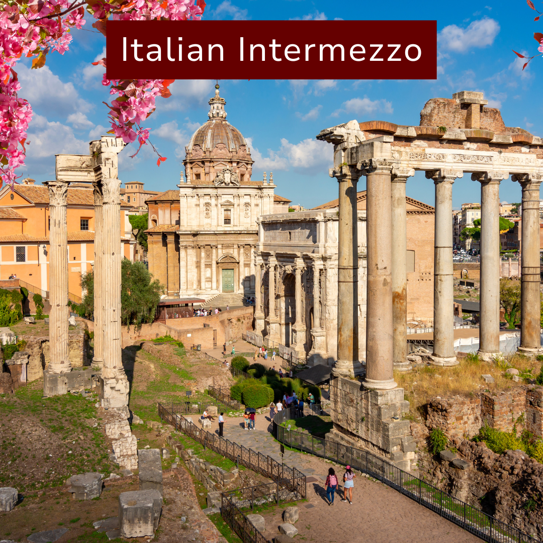 Ancient Roman ruins with columns and a historic building with a dome, under a partly cloudy sky, with pink flowering branches in the foreground and a group of tourists exploring the site.
