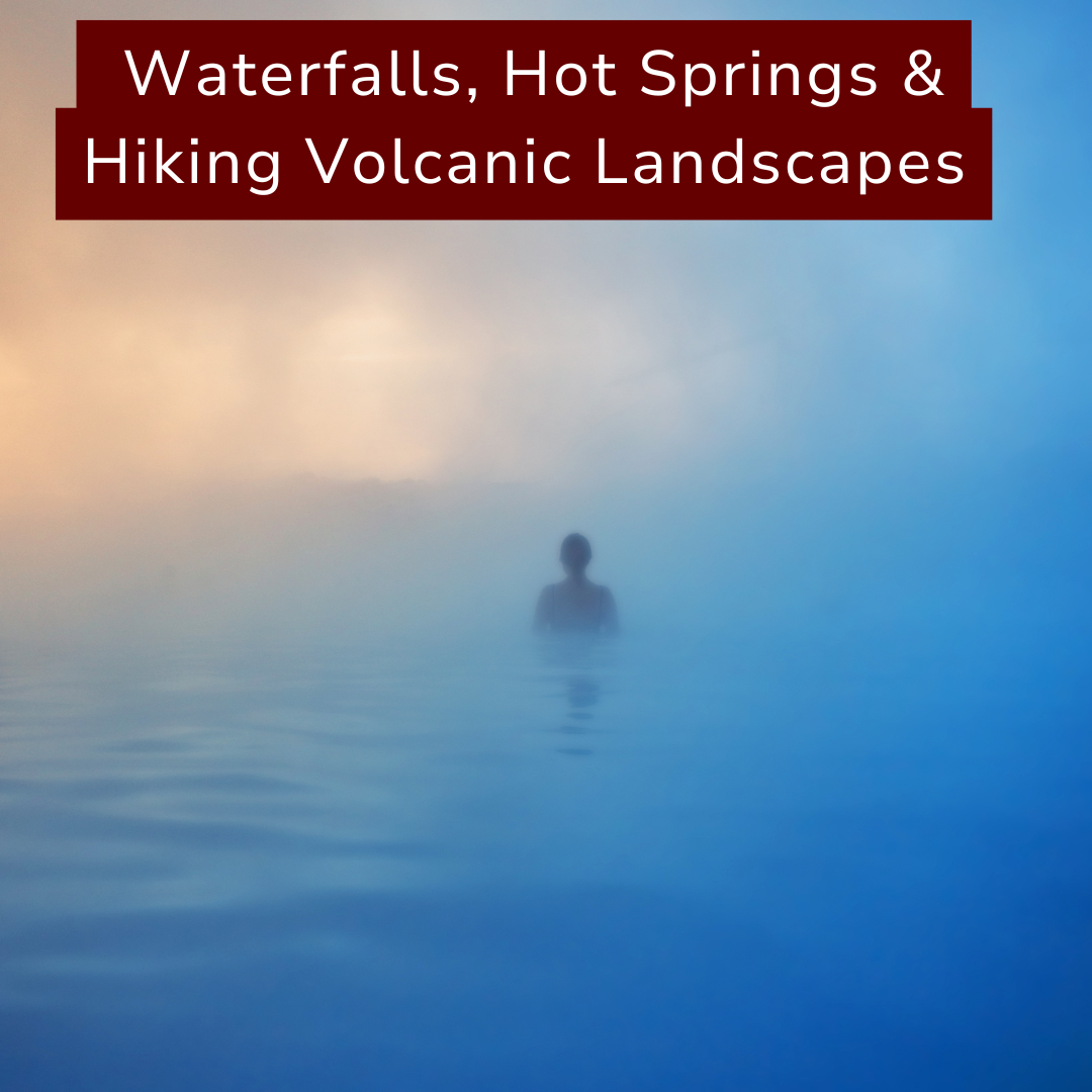 A person standing in a hot spring or geothermal pool with steam rising, surrounded by a landscape of waterfalls, hot springs, and volcanic scenery.