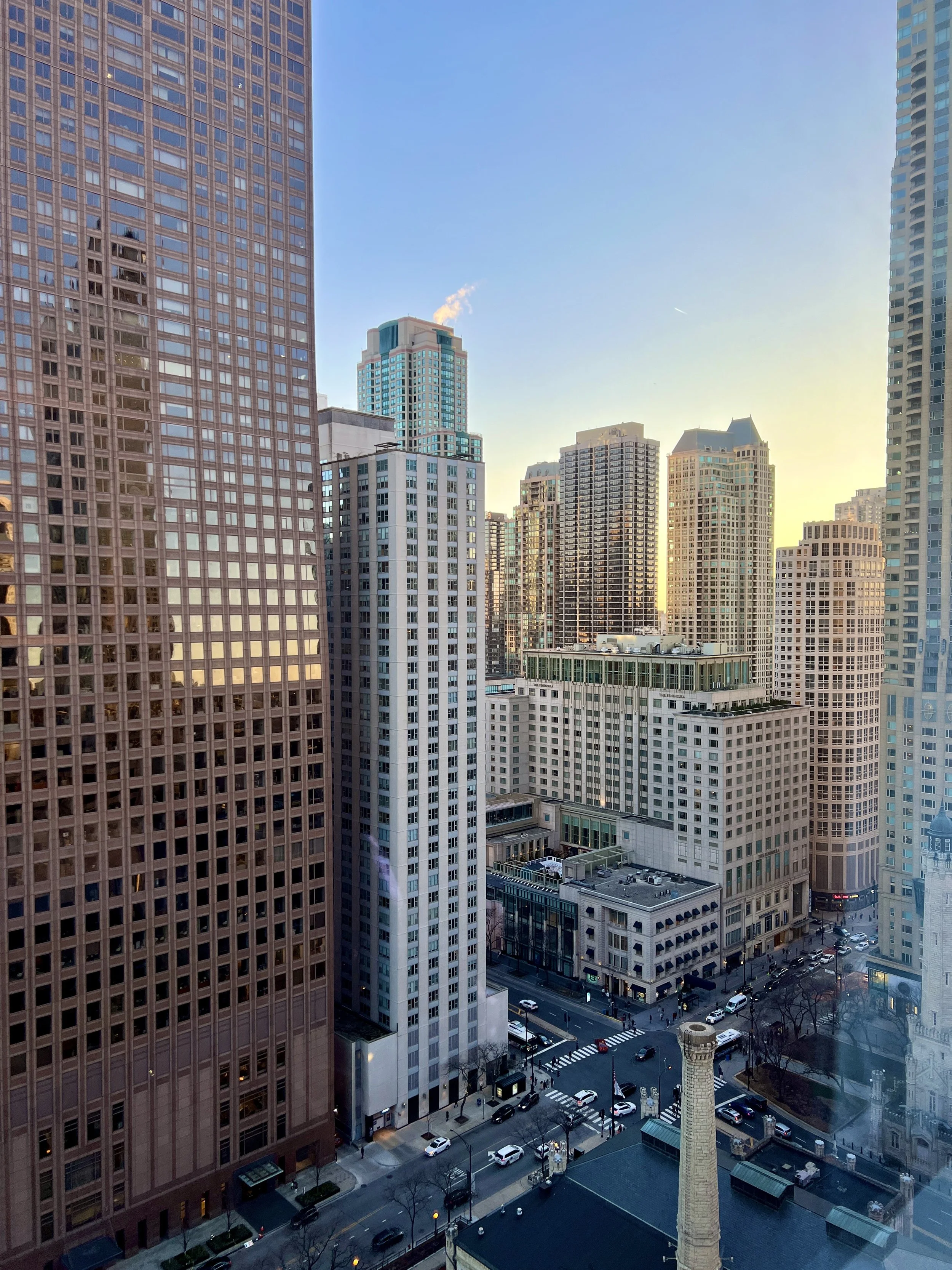 View of downtown Chicago skyline at golden hour from a high-rise hotel window.