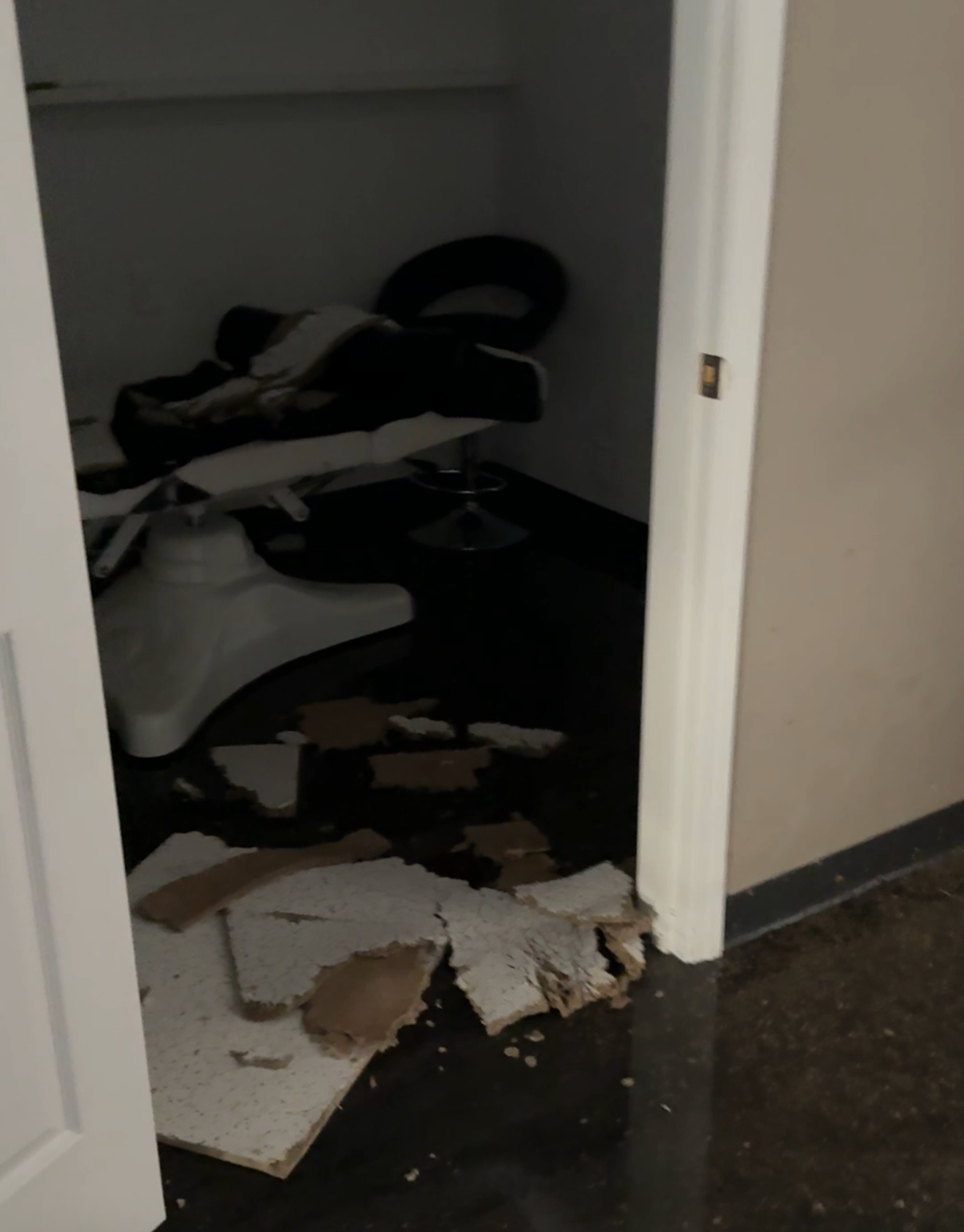 Flood damage inside Studio H salon showing standing water and fallen ceiling tiles