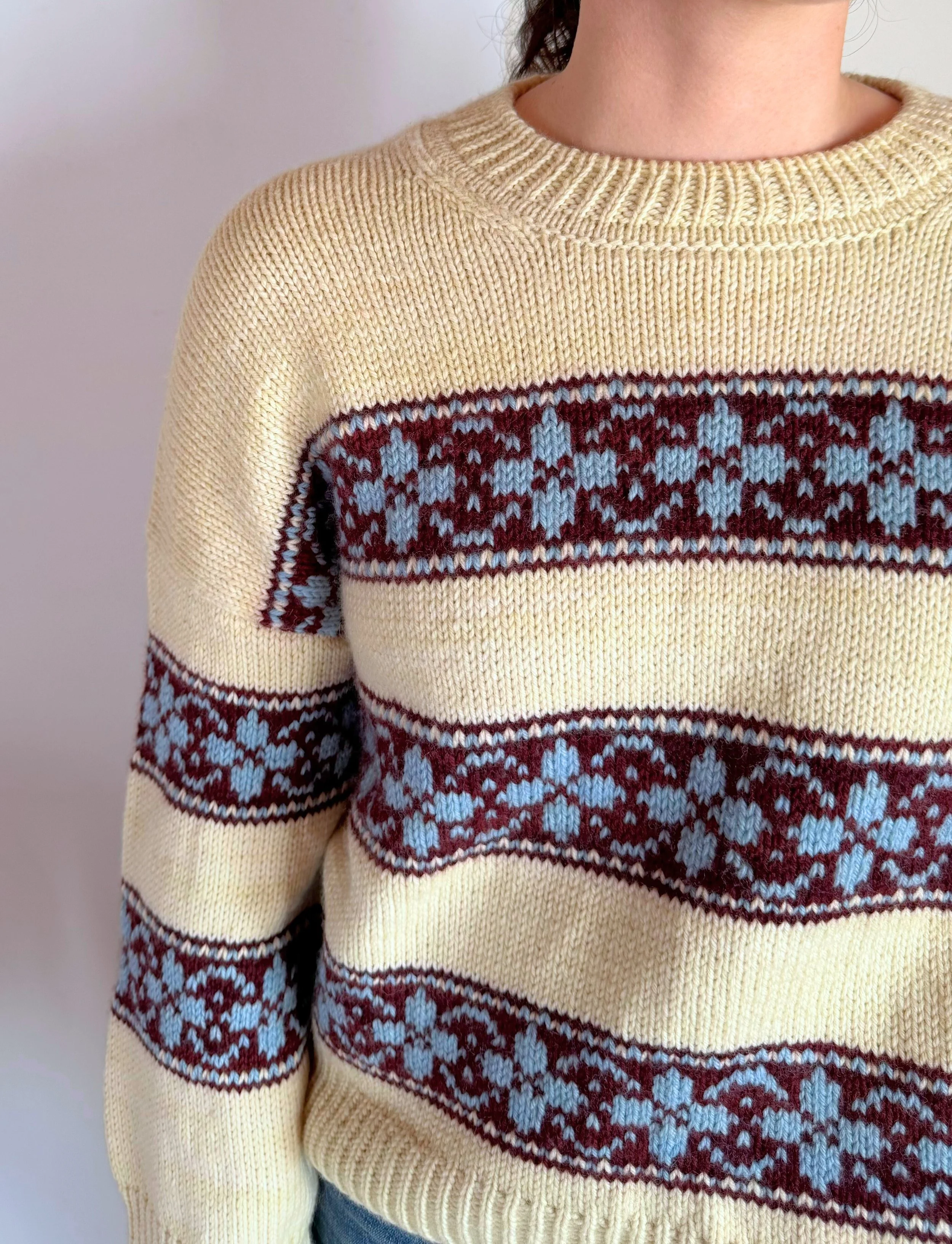 hilda sweater in yellow base with colorwork stripes in burgundy, and flowers in light blue