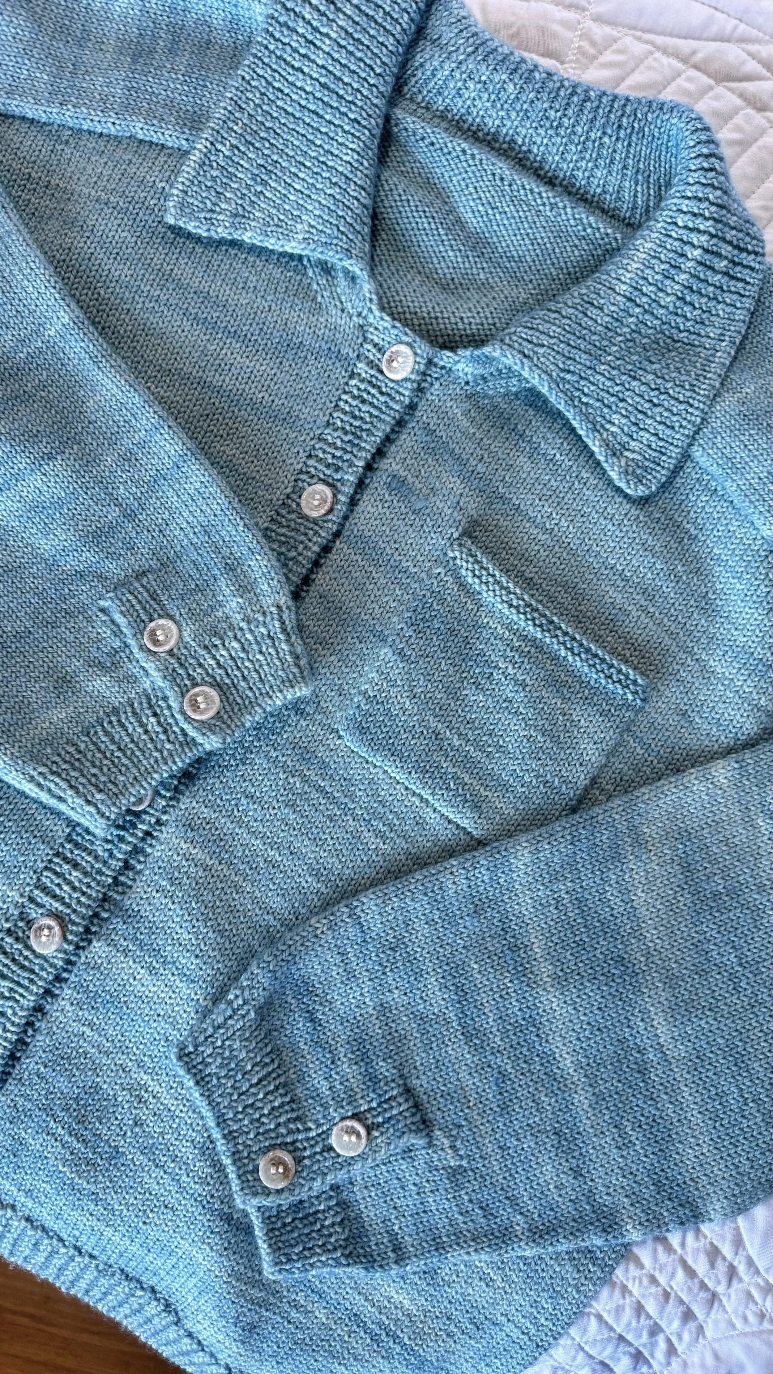 Blue cardigan with polo collar, pocket and button-down cuffs