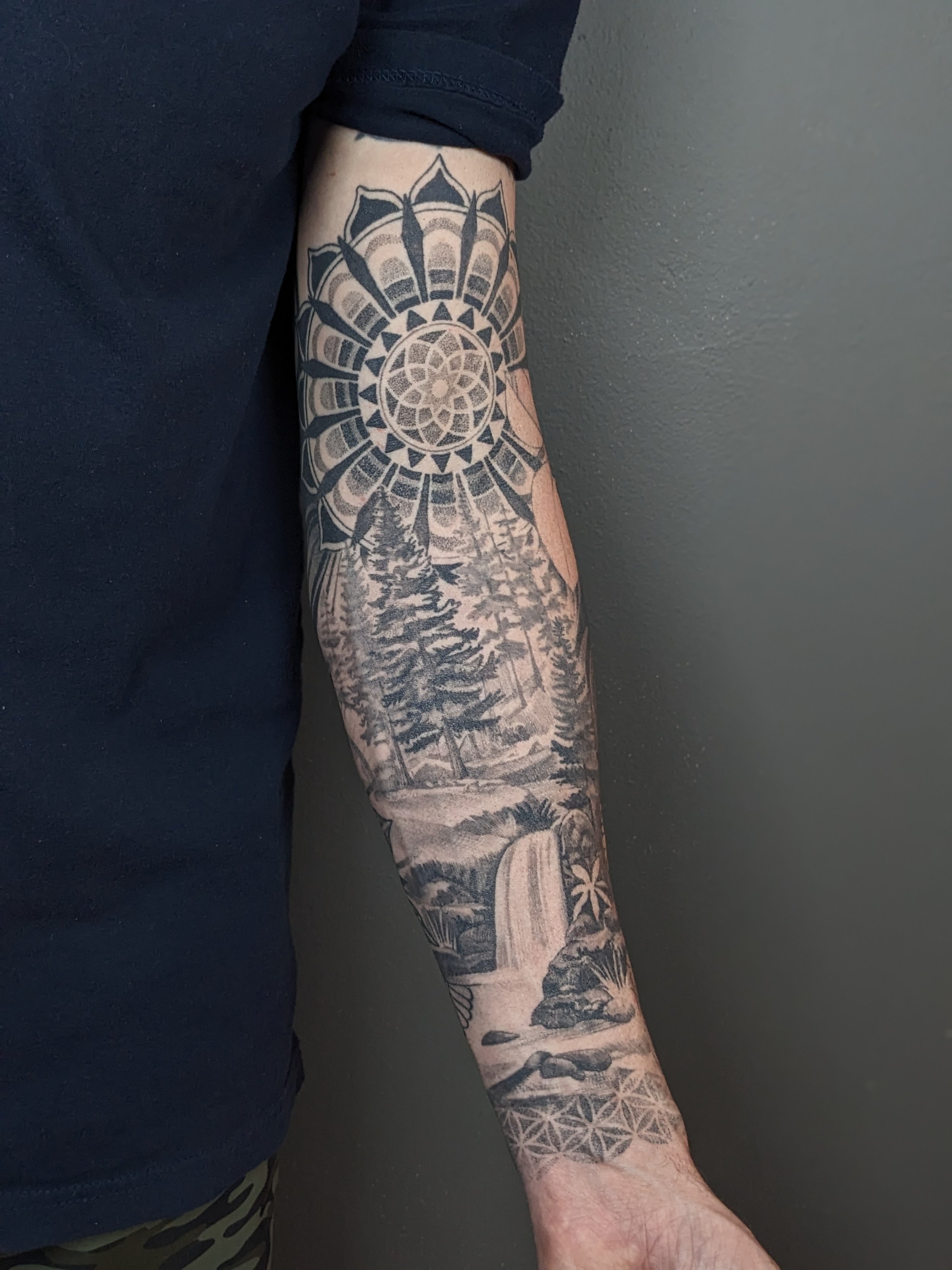 person with a black and grey landscape forearm