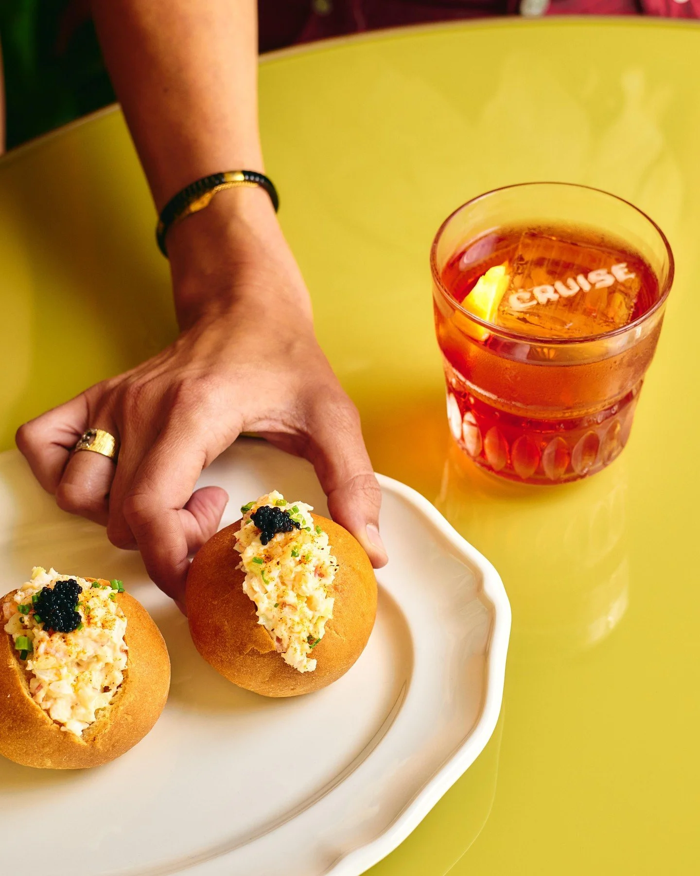 Negroni in hand, lobster roll on the table.
Sunset sips at Cruise Bar &amp; Restaurant, Monday to Friday.