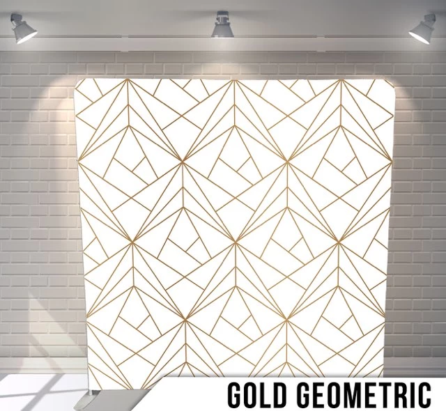 Gold geometric pattern on a white background displayed on a stand with brick wall and spotlights in the background.