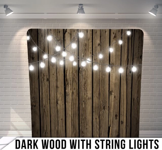 Dark wood backdrop with string lights against white brick wall.