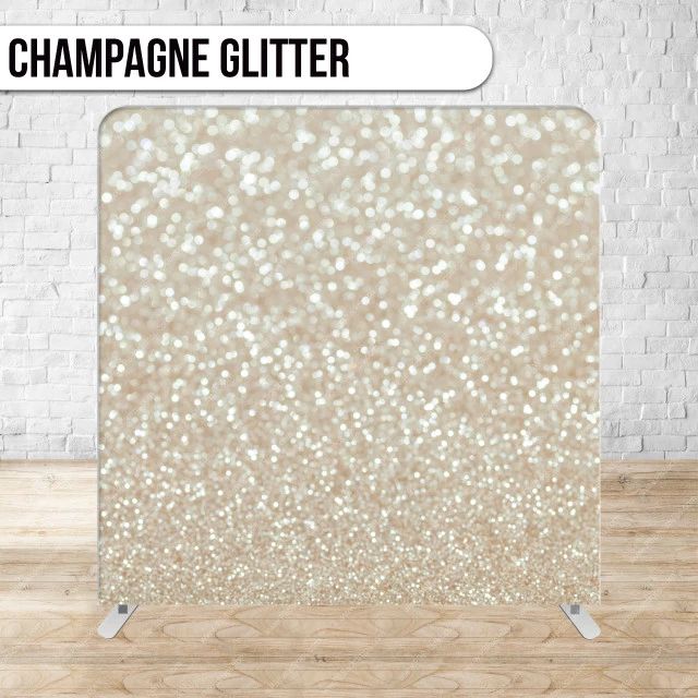Champagne glitter backdrop against a white brick wall.