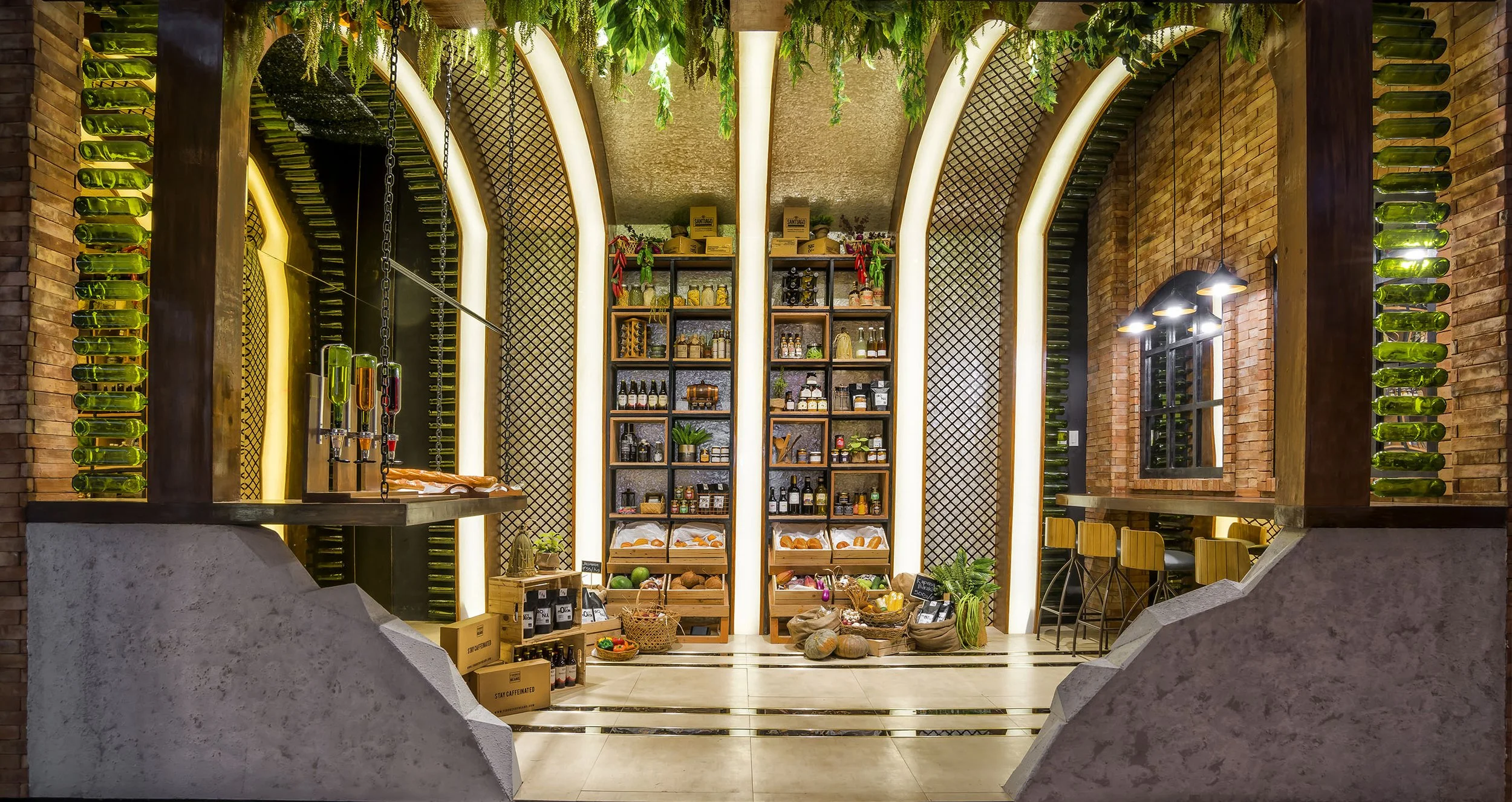 Interior of a cozy restaurant or café with brick walls, greenery hanging from the ceiling, shelves stocked with bottles, jars, and decorative items, and a countertop with various supplies. Soft lighting enhances the warm ambiance.