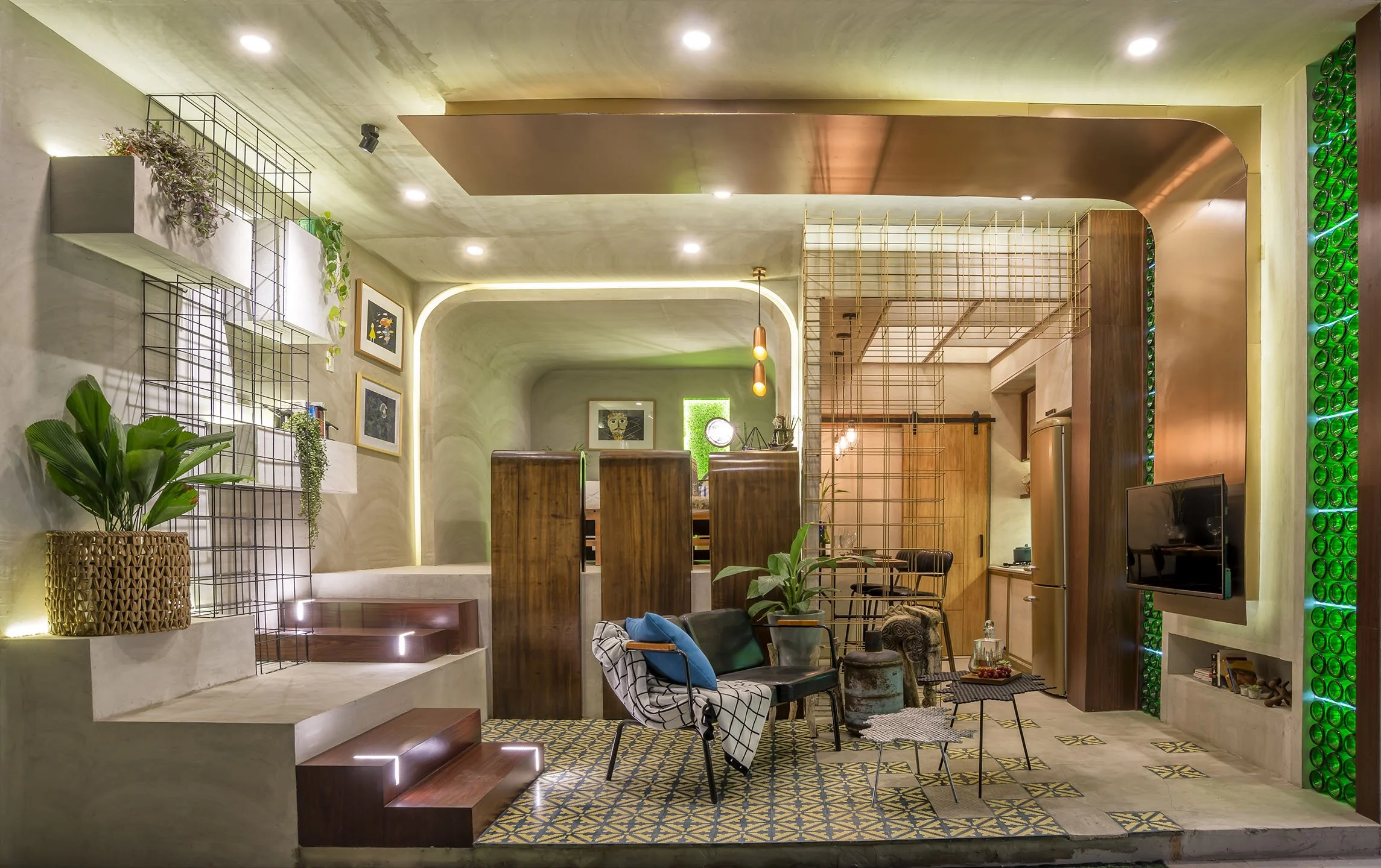 Living room with modern decor, including green plants, framed artwork on the wall, a patterned tile floor, a seating area with chairs and a sofa, and decorative lighting features.